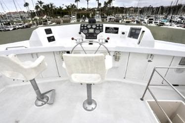 Helm of 1989 custom boat with dual seats and marina view.