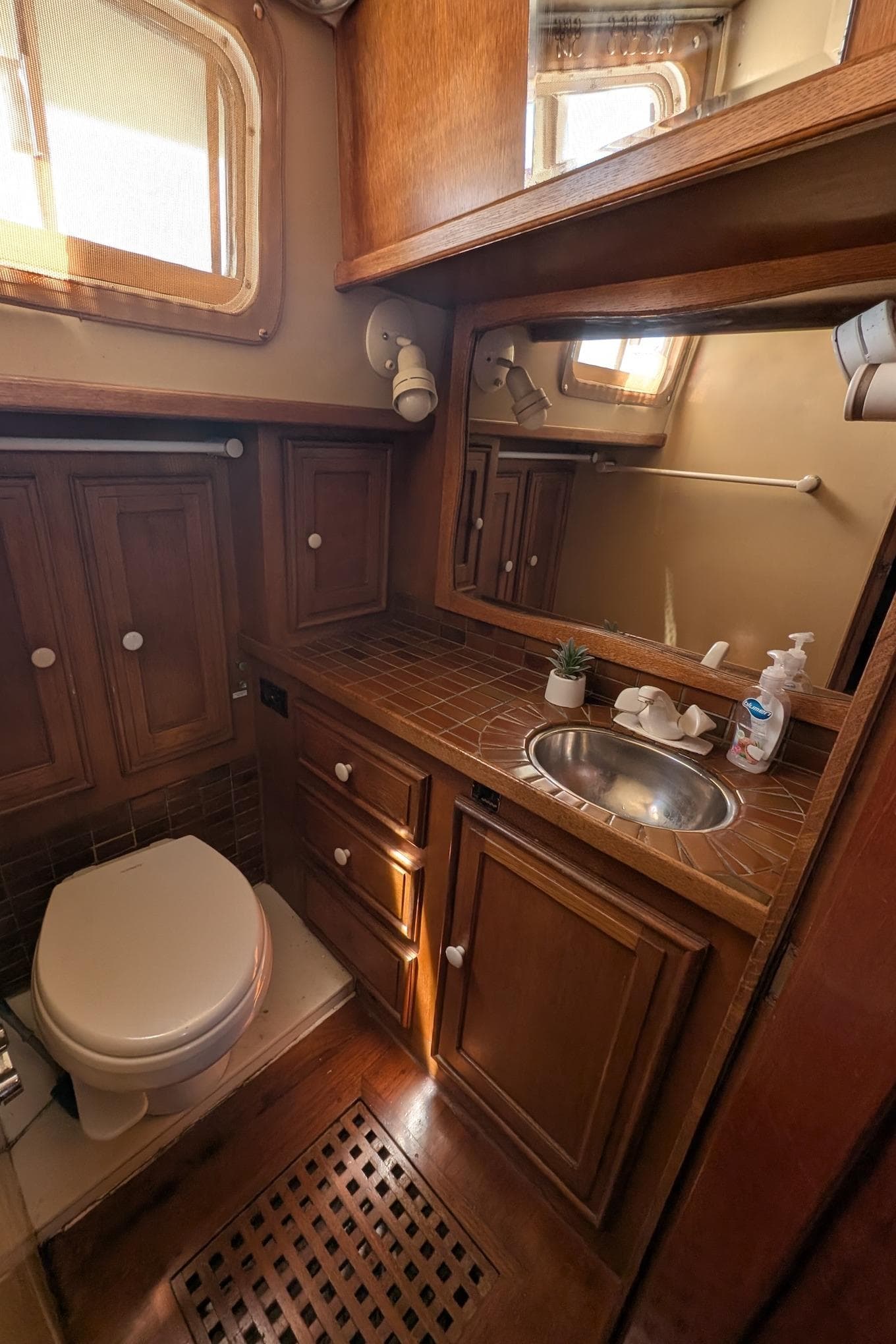 1973 Maple Leaf 48 yacht bathroom with wooden cabinetry and stainless steel sink.