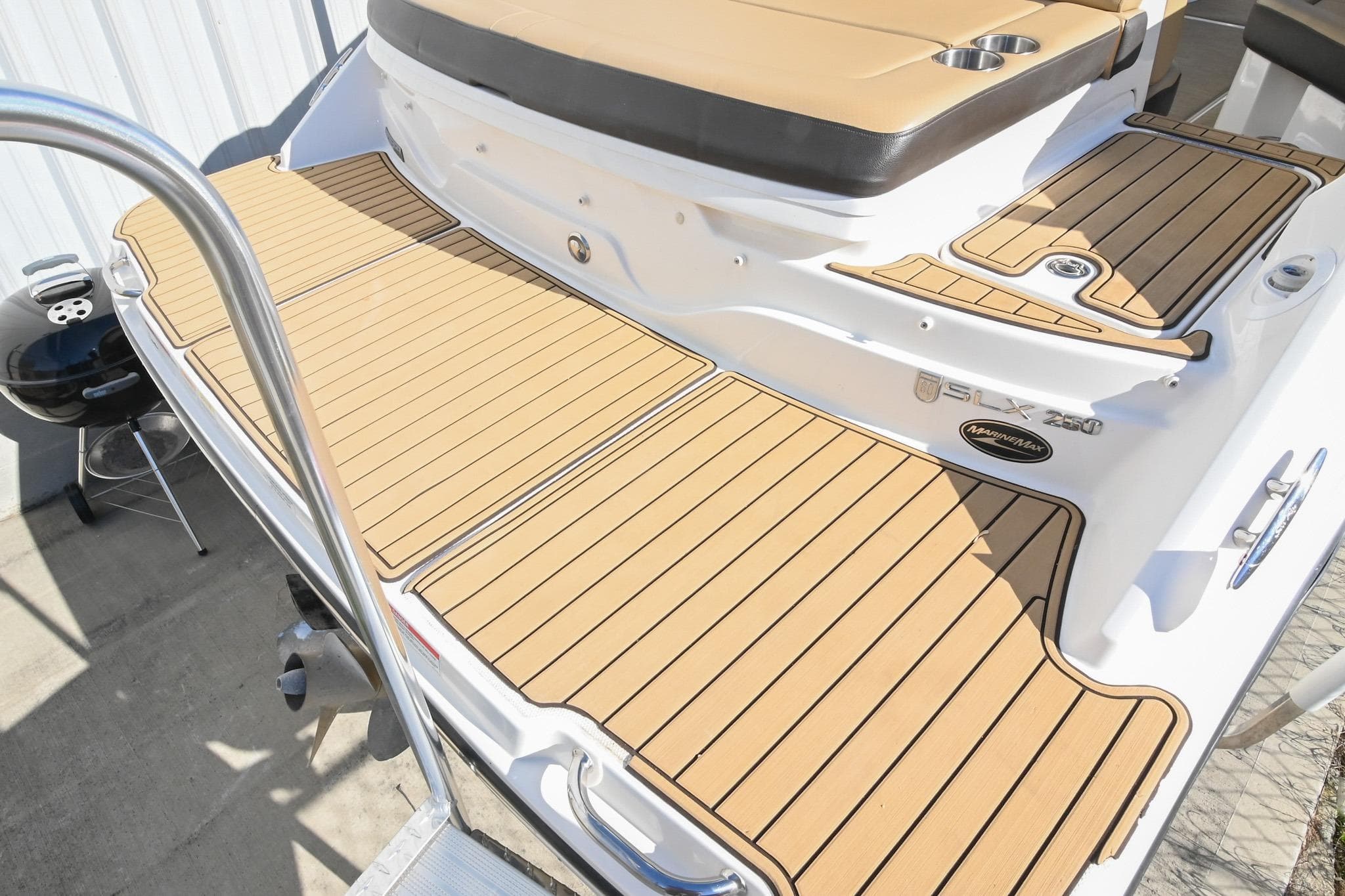 2020 Sea Ray SLX 250 boat with teak-style decking and stainless steel railing.