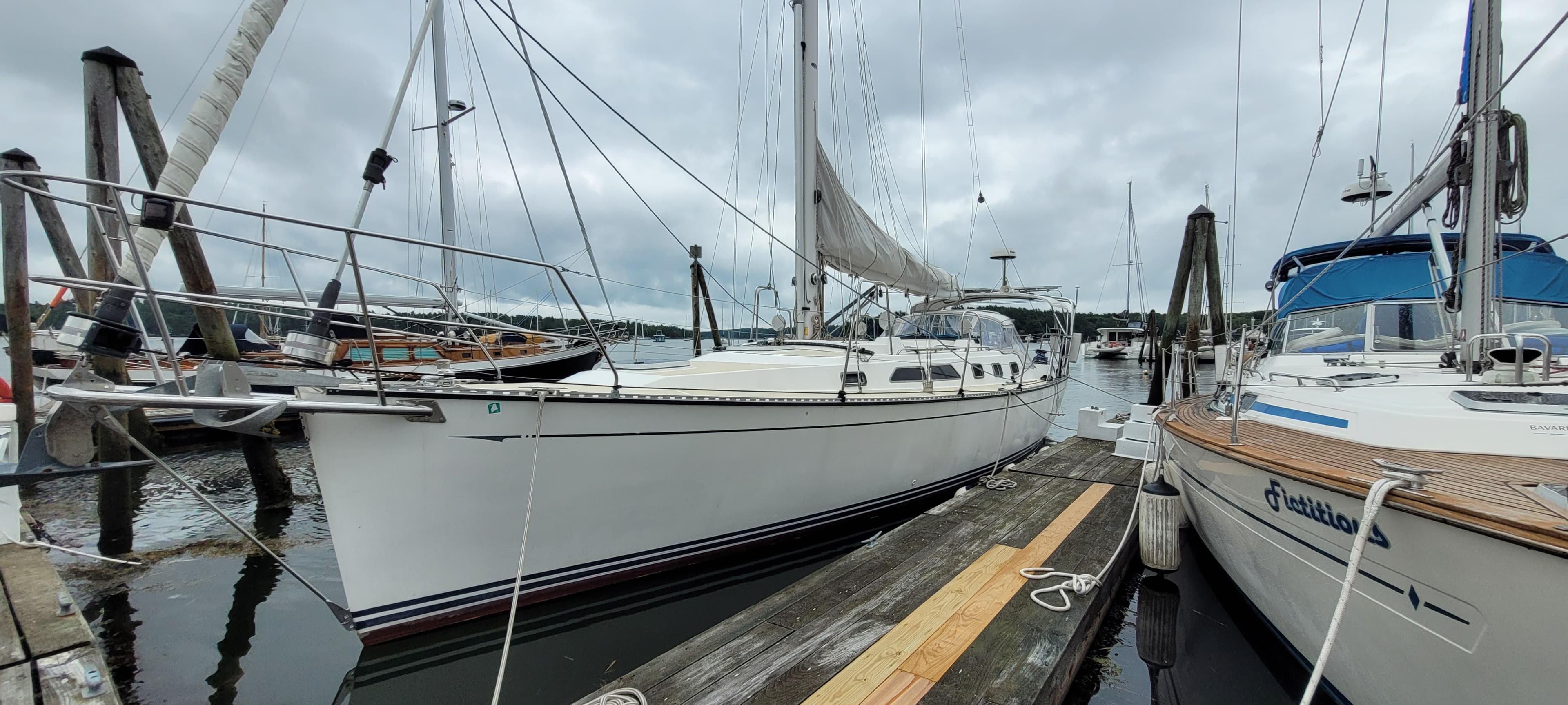 Sailboat docked at marina, Saga 43 model from 1997, overcast sky.