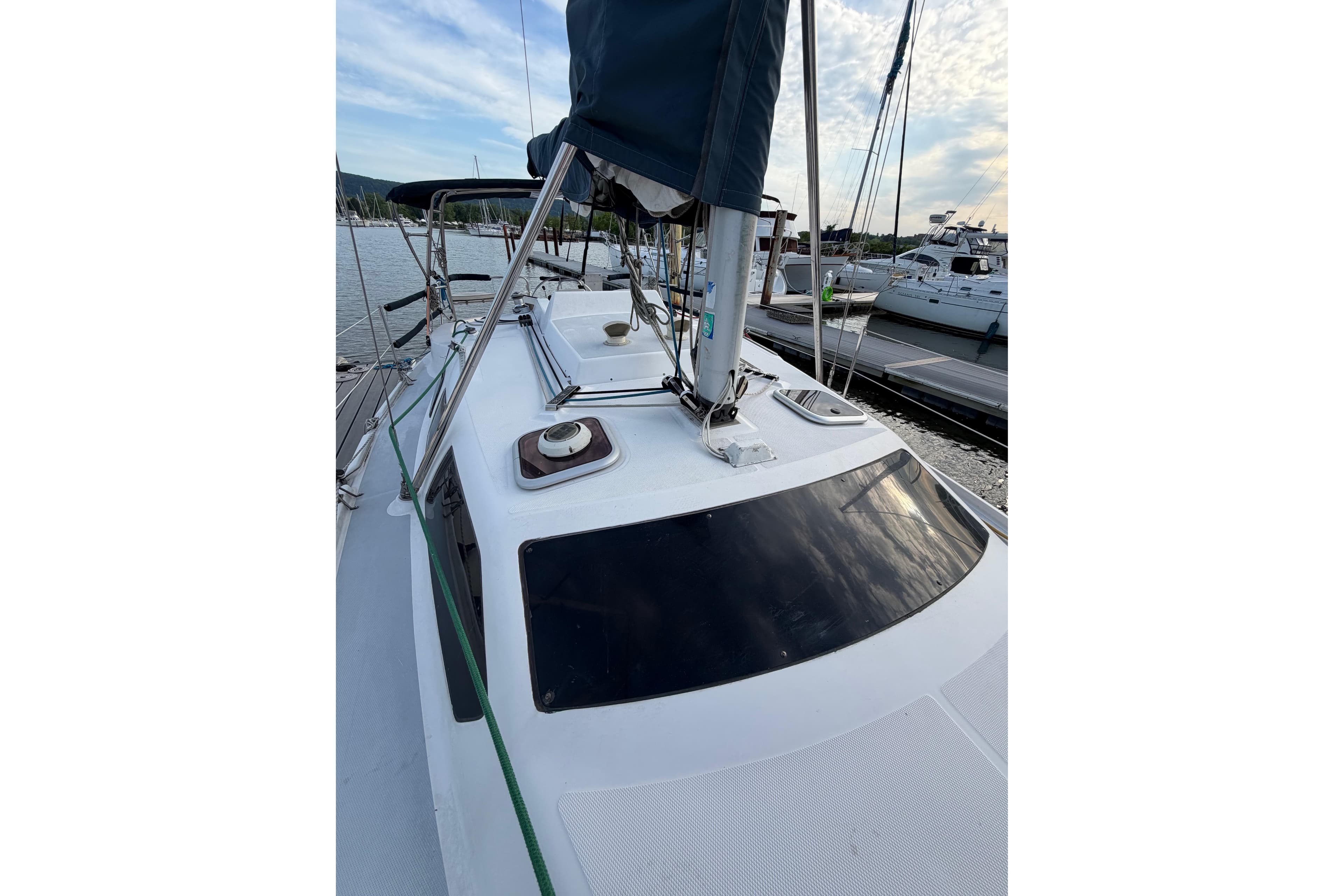 2000 Hunter 310 sailboat docked at marina, showcasing deck and rigging.