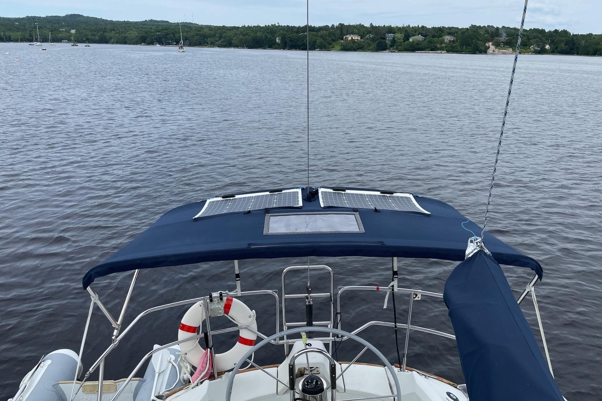 1985 C&C 33 MK 2 sailboat with solar panels on calm water.