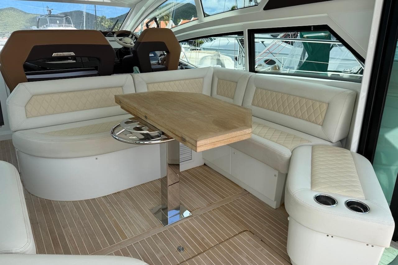 Luxurious interior of 2018 Beneteau Gran Turismo 46 yacht with elegant seating and wooden table.