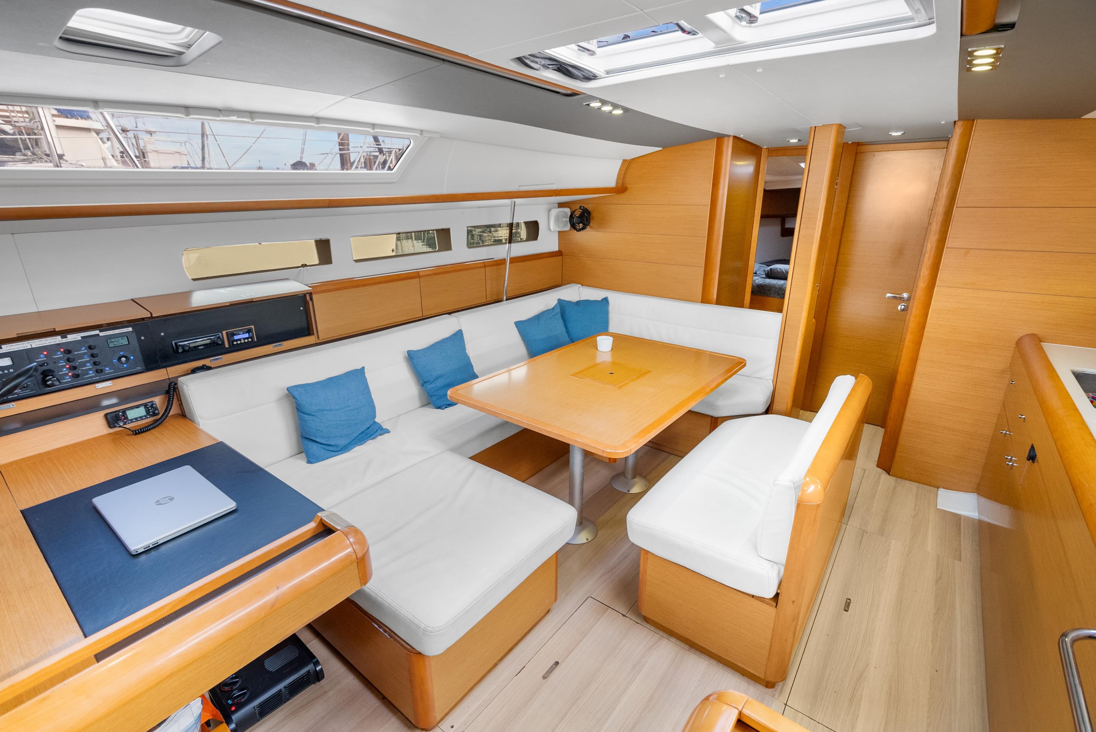 Interior of 2015 Jeanneau Sun Odyssey 509 yacht with modern seating and dining area.
