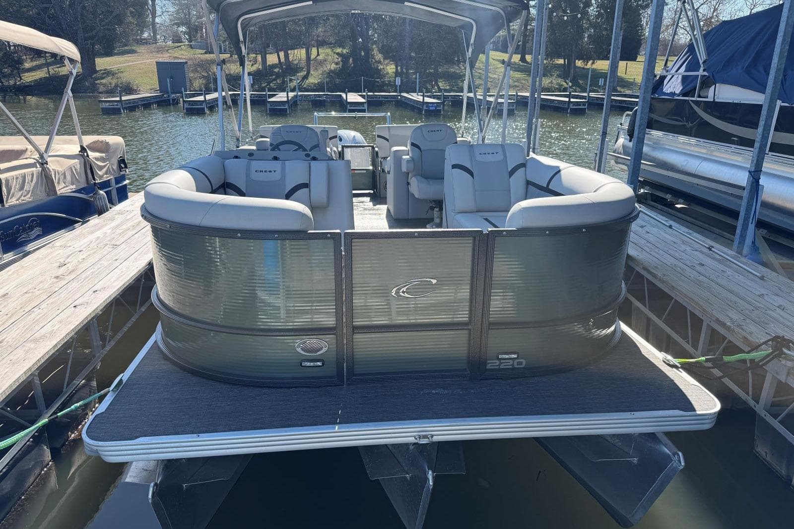 2024 Crest Classic LX 220 SLRC pontoon boat docked on a sunny day.