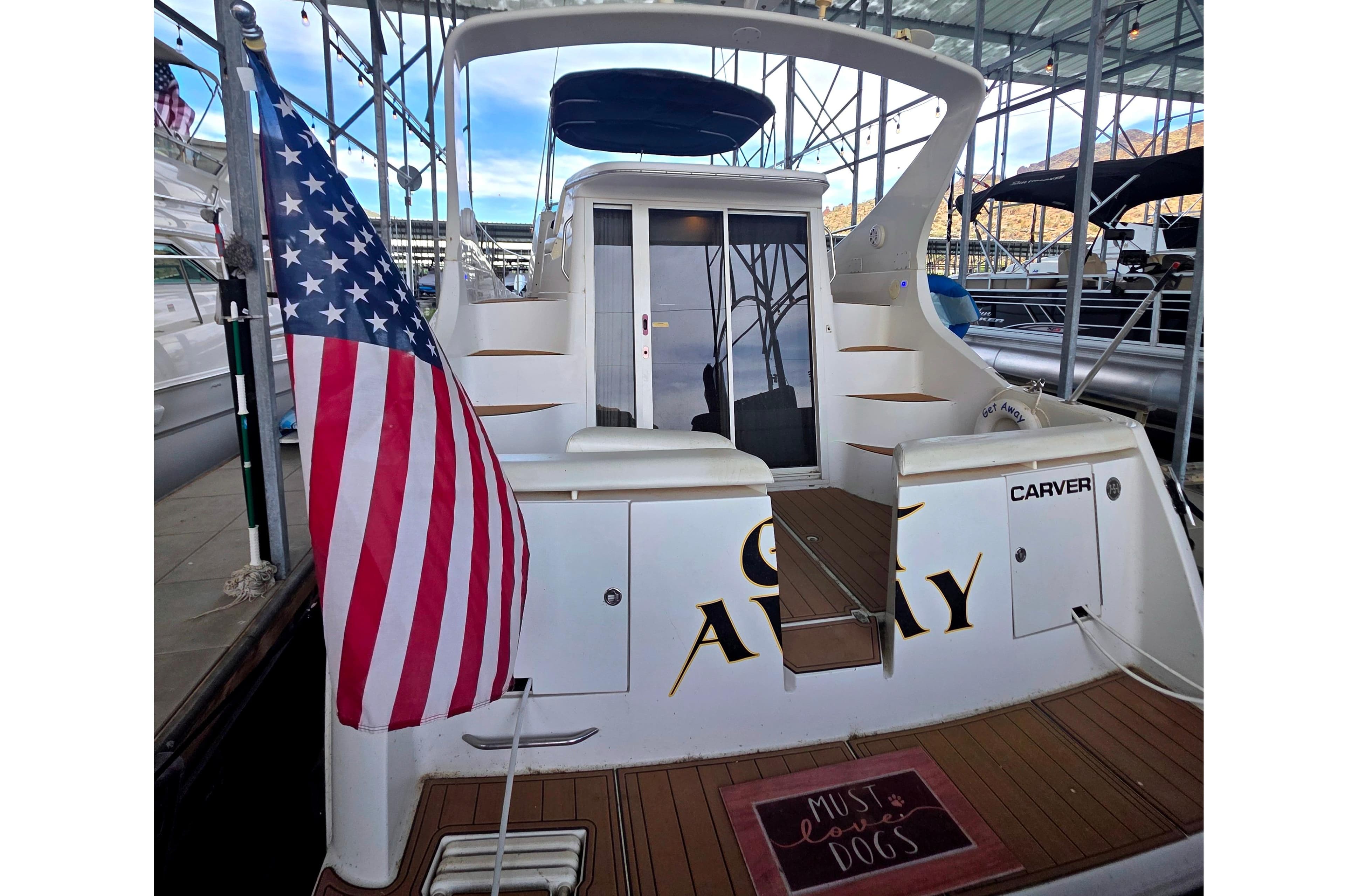 2001 Carver 350 Mariner yacht with American flag, docked in marina.