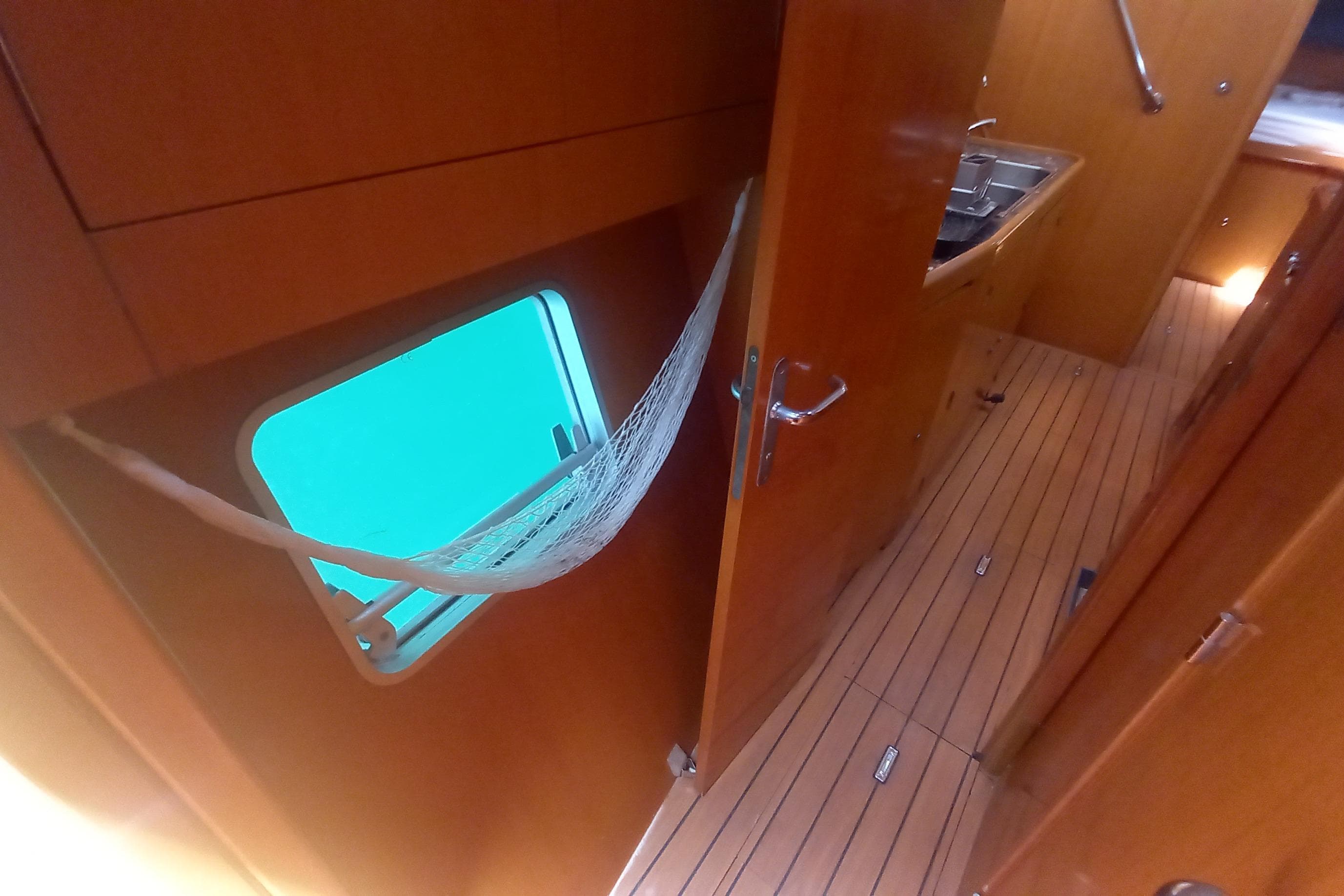 Interior of 2002 Lagoon 470 yacht with wooden finish and hammock by window.
