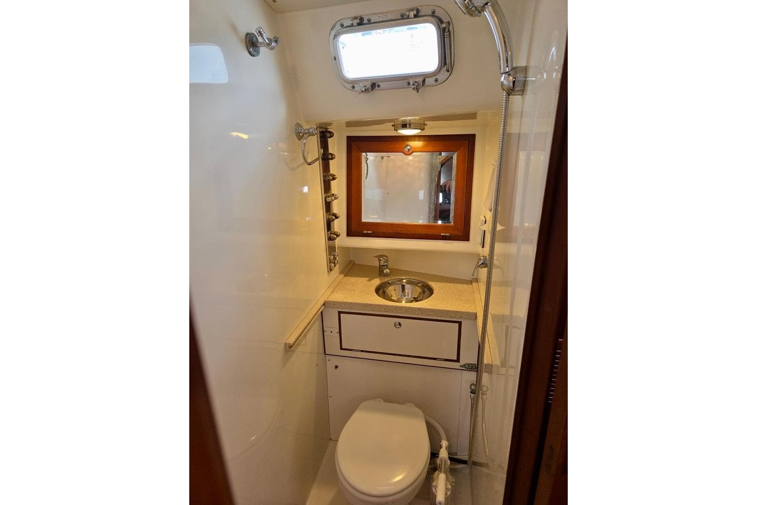 Compact bathroom in 2006 Outbound 44 yacht with sink, toilet, and mirror.
