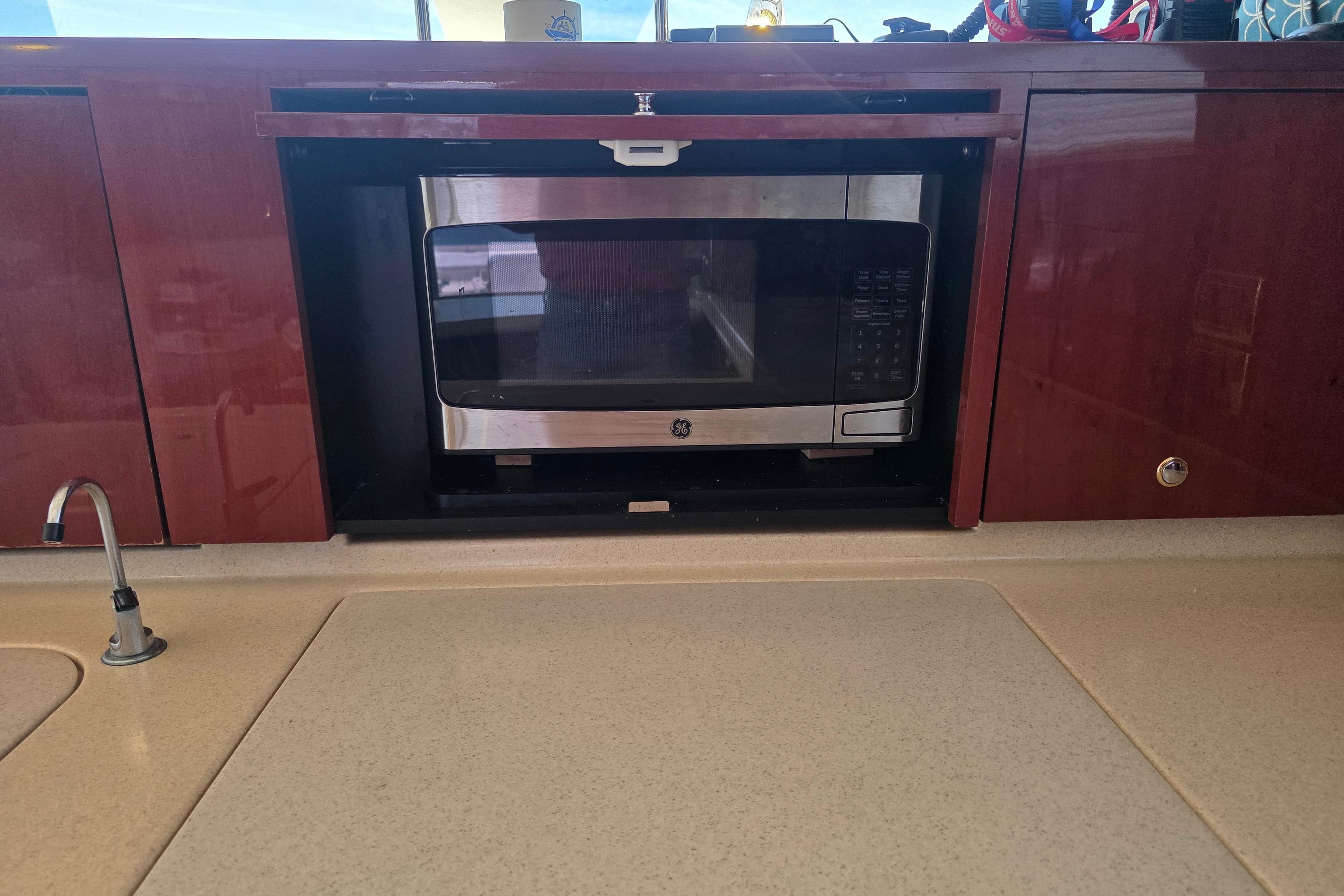Microwave in 2002 Sea Ray 560 Sedan Bridge yacht kitchen with wooden cabinetry.