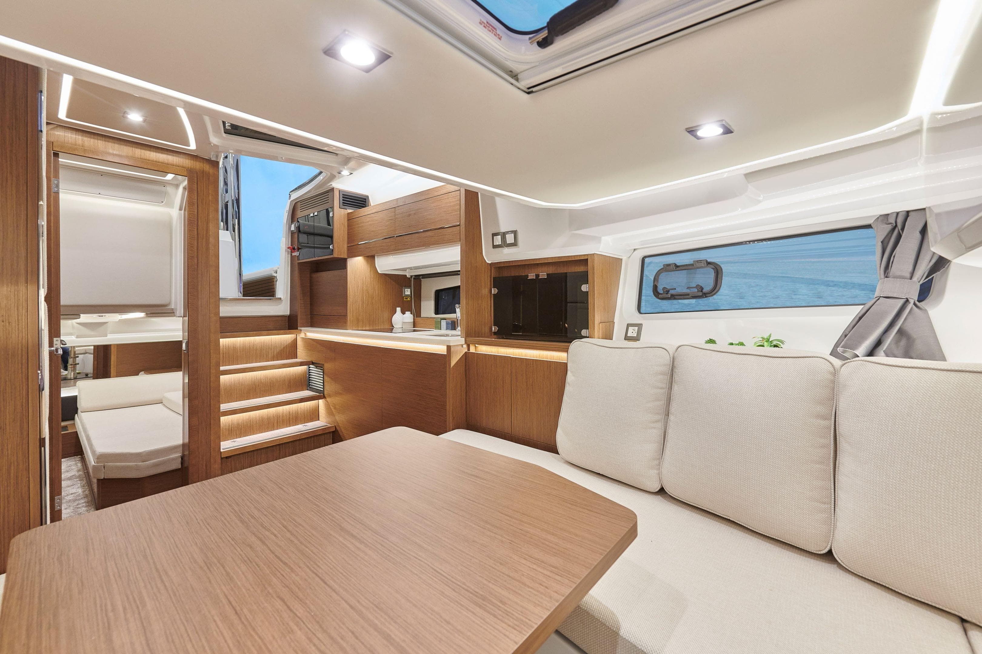 Luxurious interior of 2026 Jeanneau Leader 12.5 WA yacht with modern wood finish.