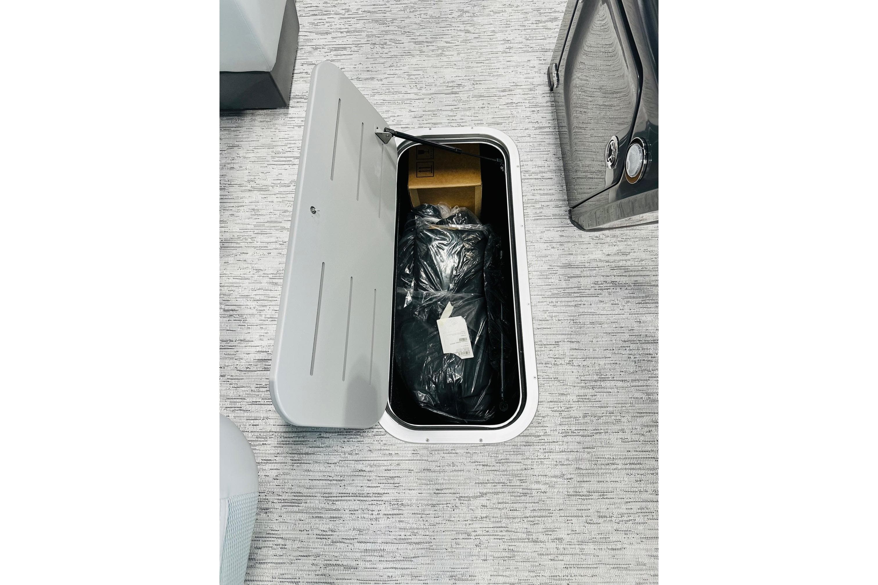 Open storage compartment on 2026 Bennington 22 SSR boat, revealing interior contents.