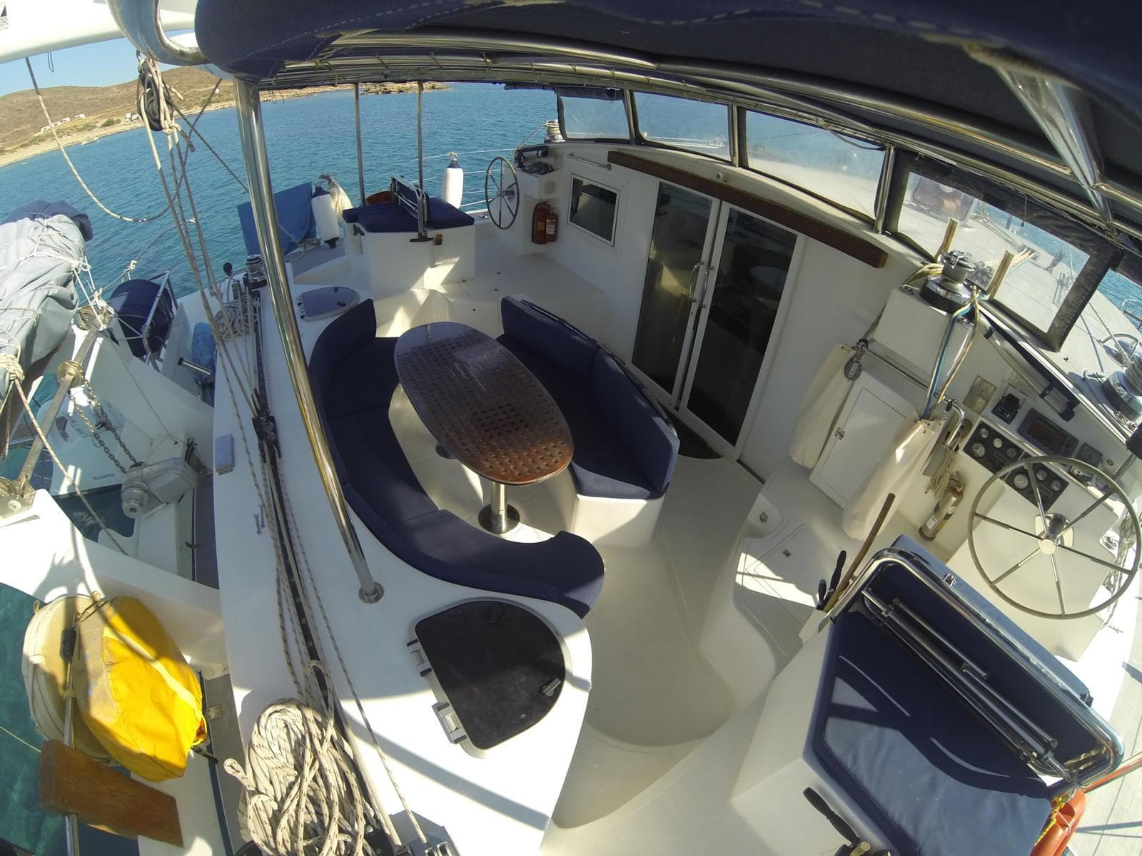 Cockpit of 2007 Custom ISoCatamarans 60 with blue seating and wooden table.