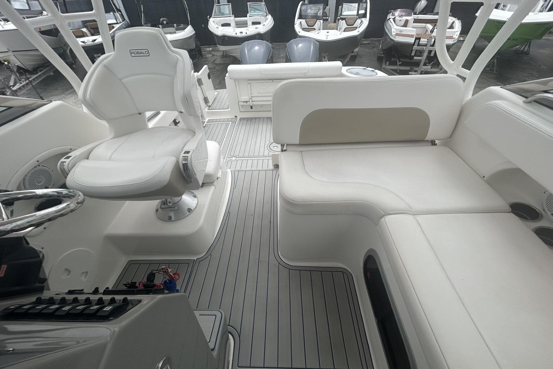 2018 Robalo R305 Walkaround boat interior with white seating and steering area.
