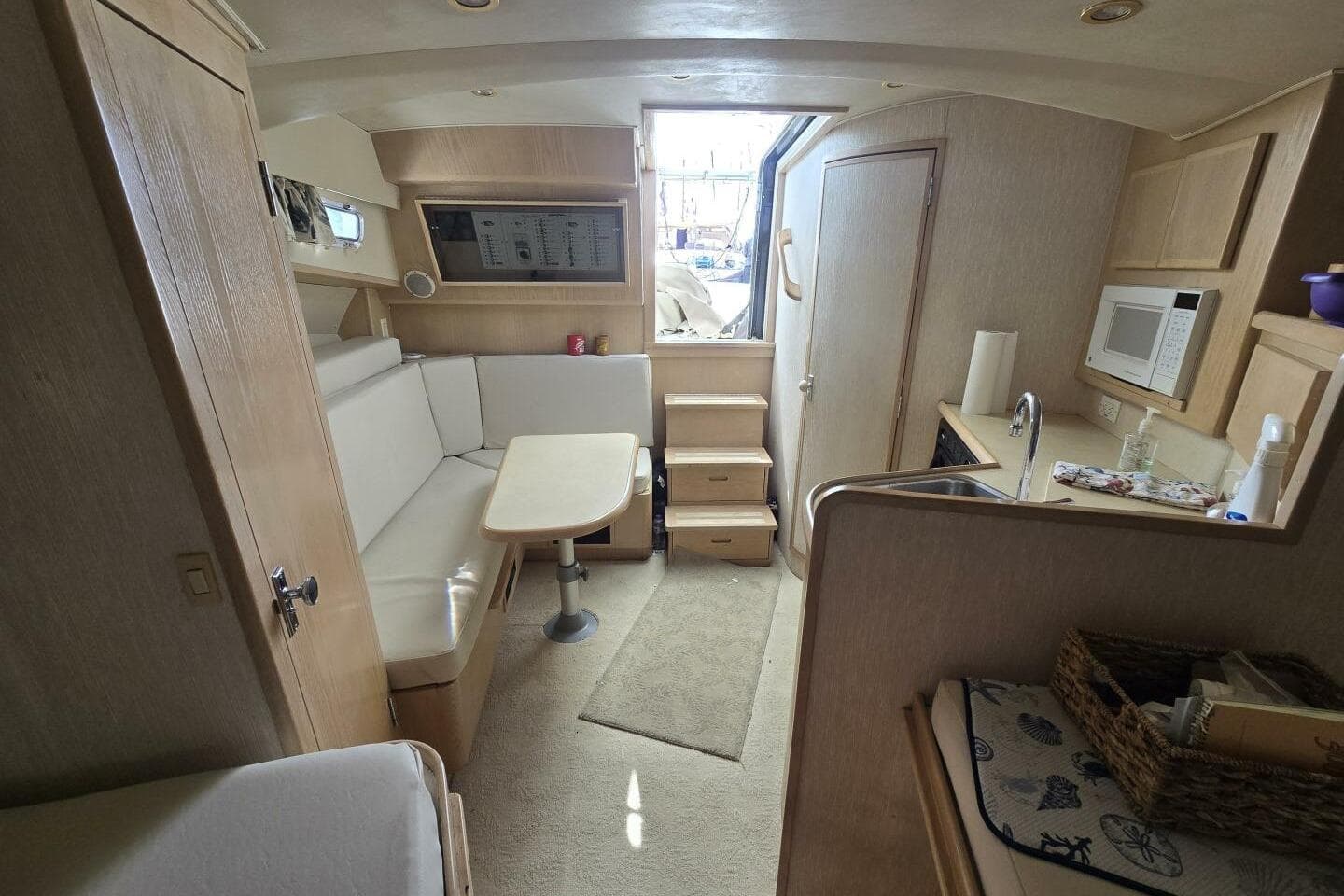 Interior of 2000 Henriques 35 Express boat with seating, table, and kitchenette.
