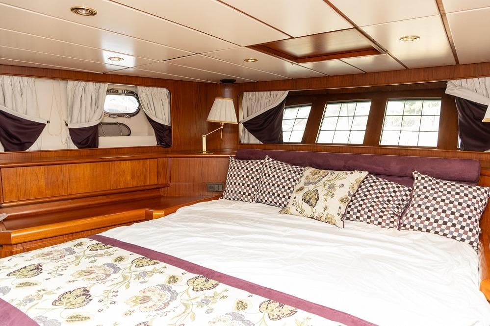 Luxurious bedroom interior on a 1996 Jongert 30M yacht, featuring elegant wood paneling.