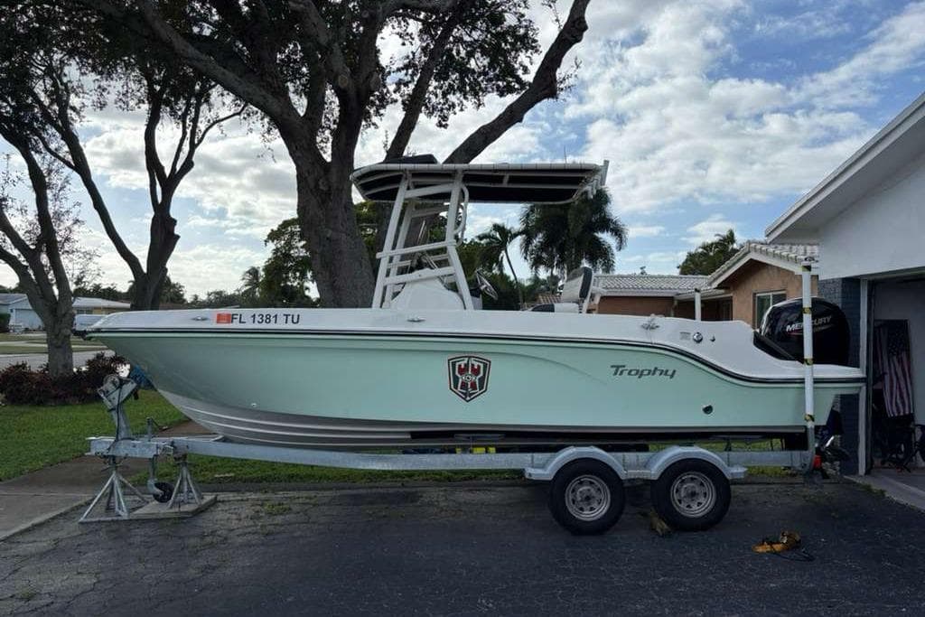 2023 Bayliner Trophy T22CC boat on trailer, parked in residential driveway.