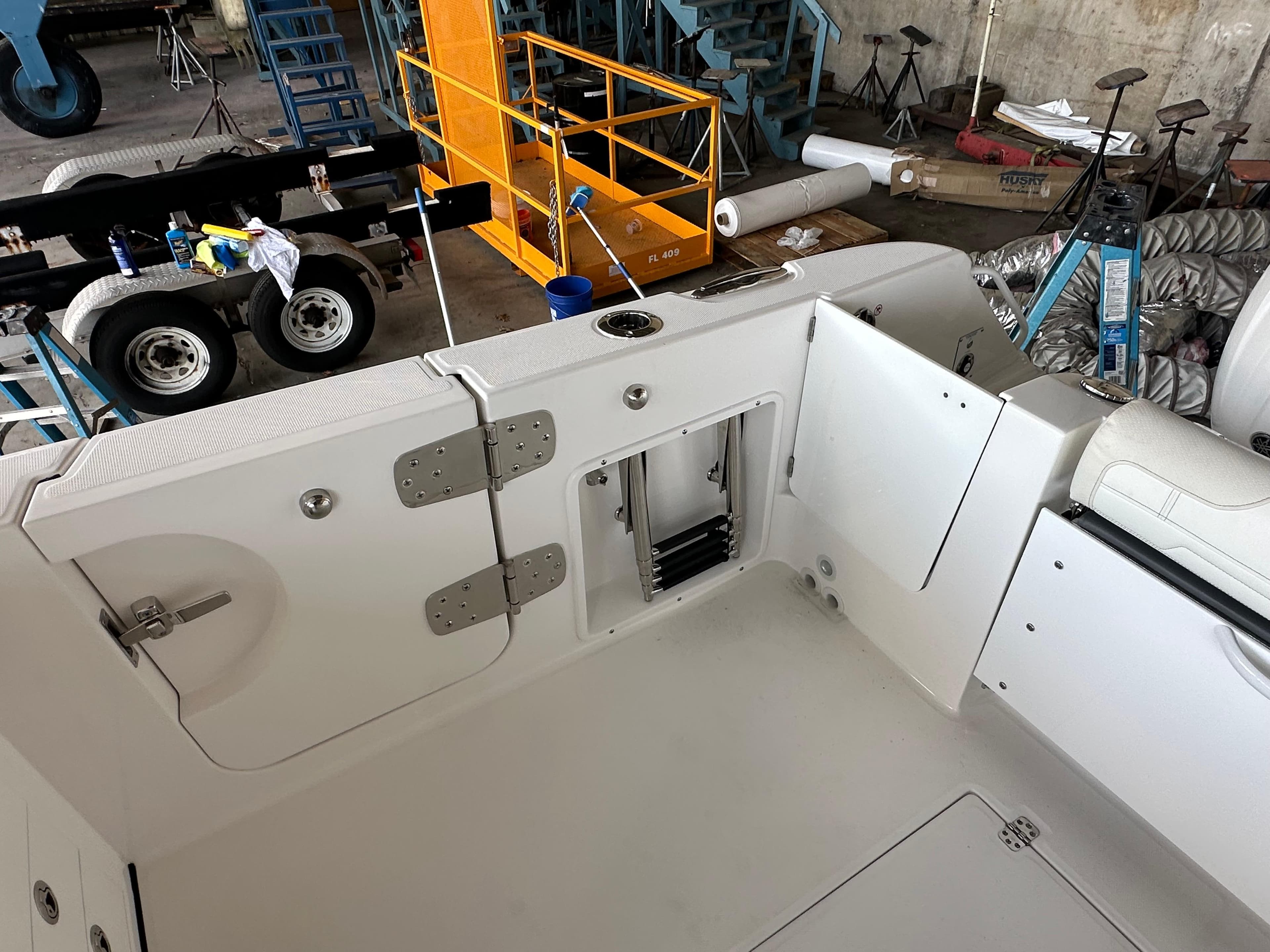 2026 Edgewater 262CX Crossover boat interior with open storage compartments in a workshop setting.