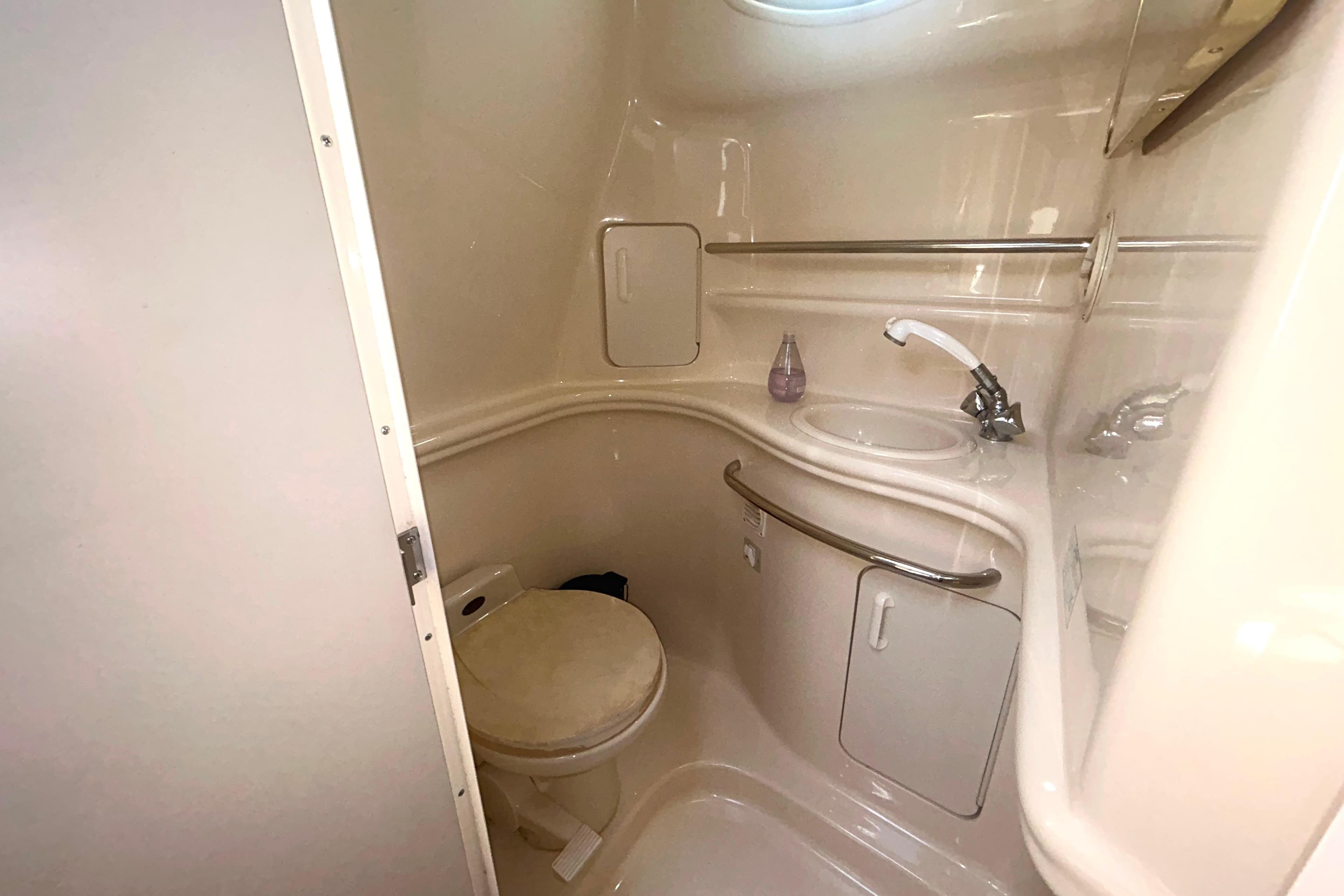 Compact bathroom in a 2000 Sea Ray 340 Sundancer yacht, featuring a toilet and sink.