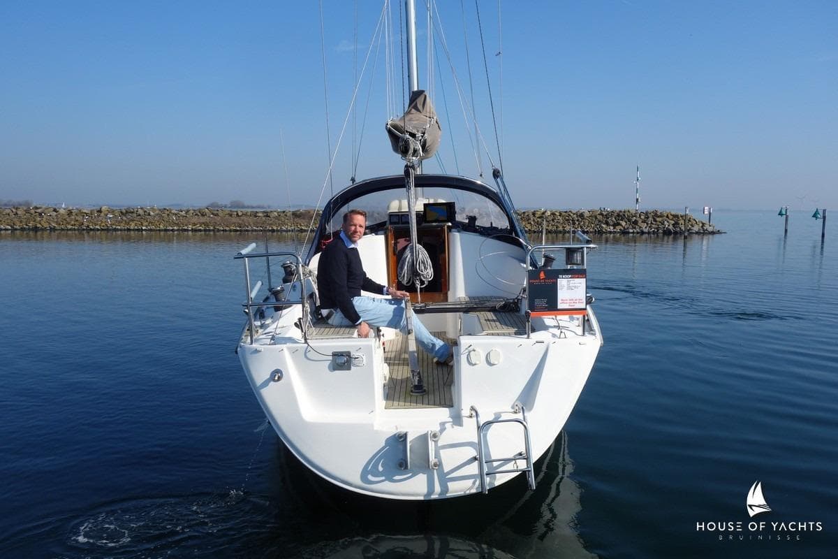 Man on a 2007 Hanse 315 yacht, calm waters, clear sky.