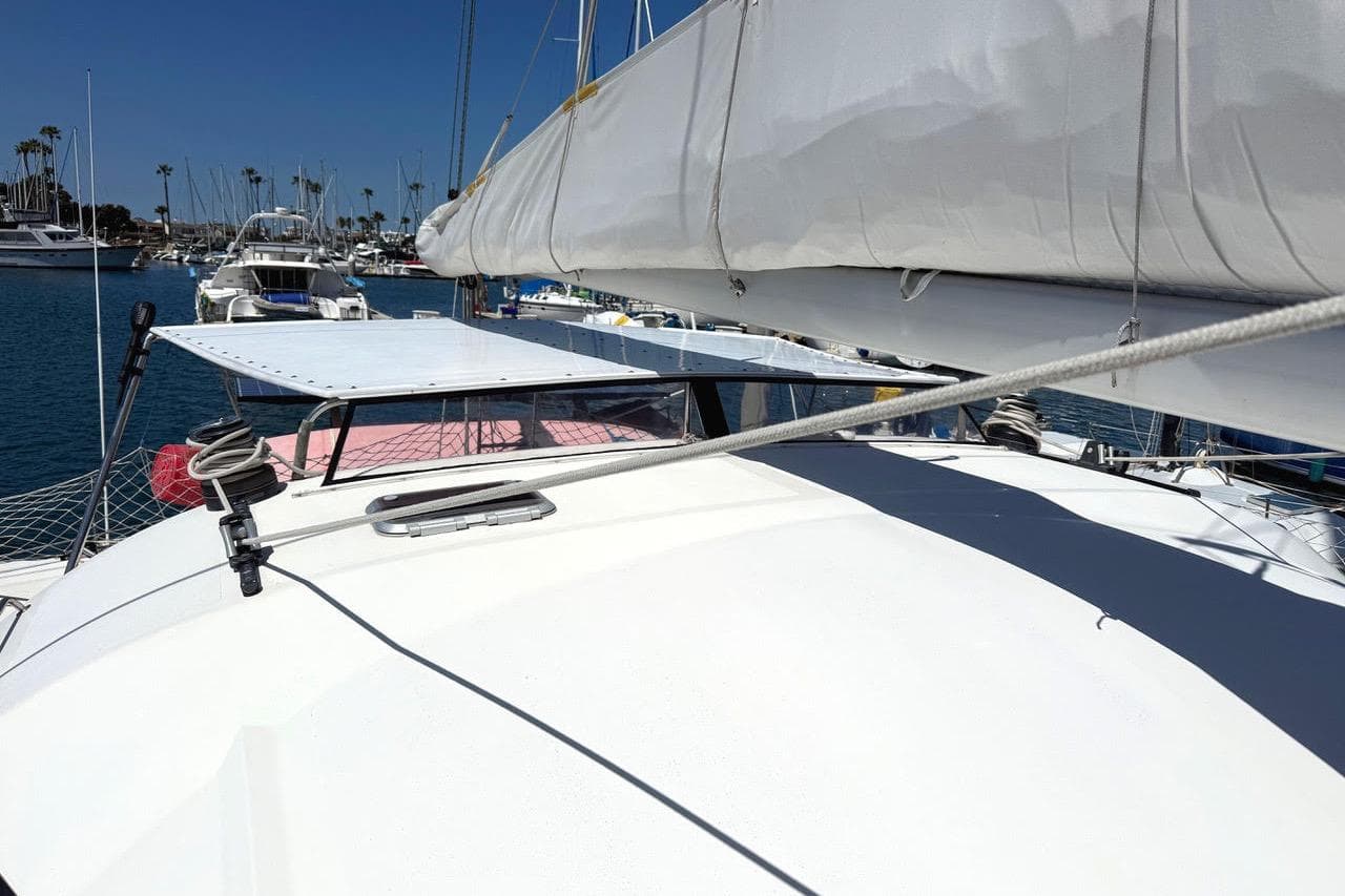 2004 Outremer Standard catamaran docked in a marina, featuring sails and deck equipment.