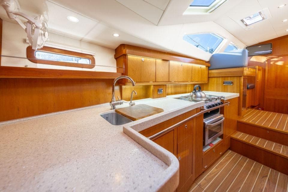 Luxurious interior of 2013 Southerly 42RST yacht with modern kitchen and wooden cabinetry.