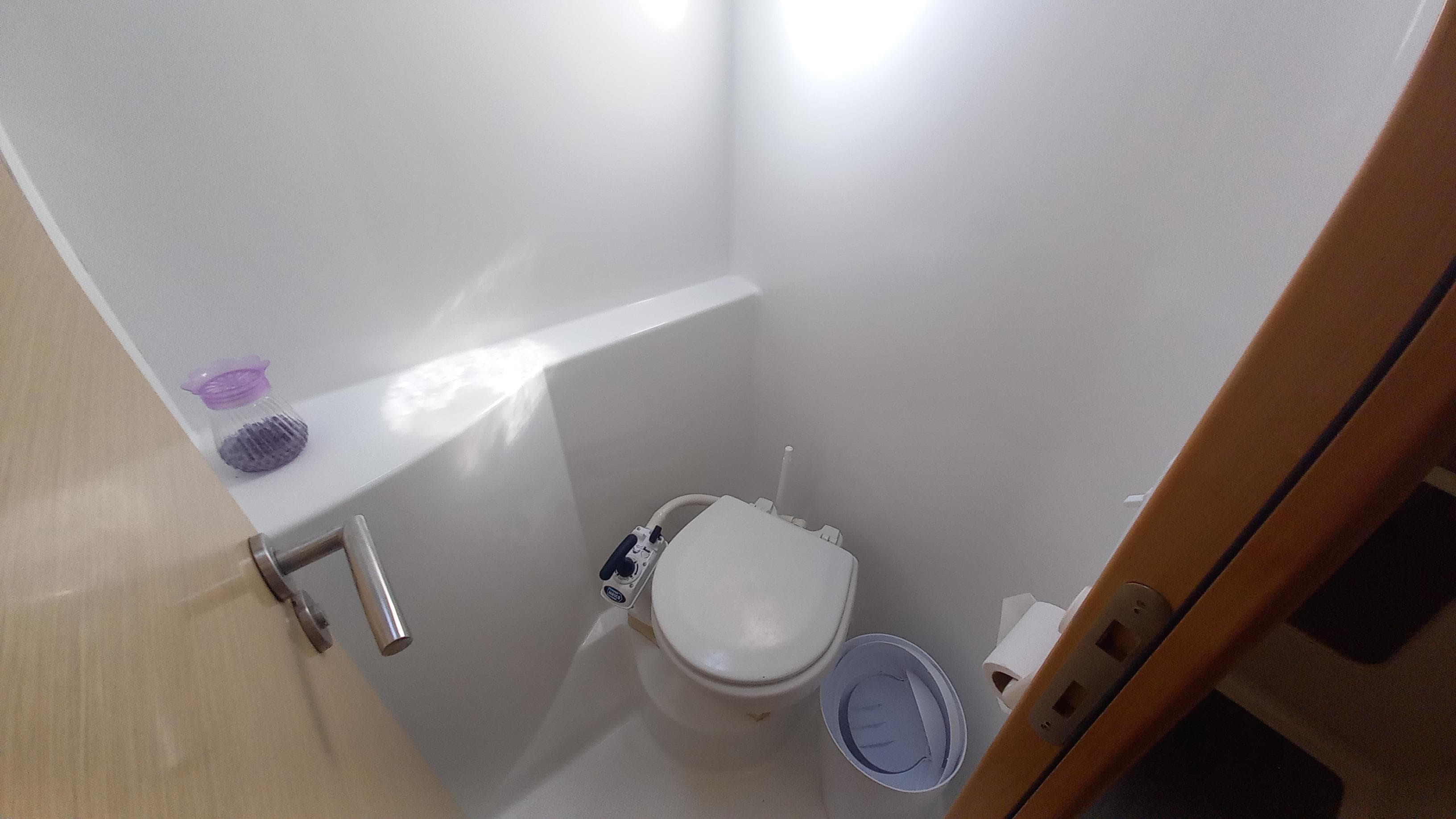 Compact bathroom in 2015 Fountaine Pajot Lipari 41 catamaran, featuring a modern toilet and minimalistic design.