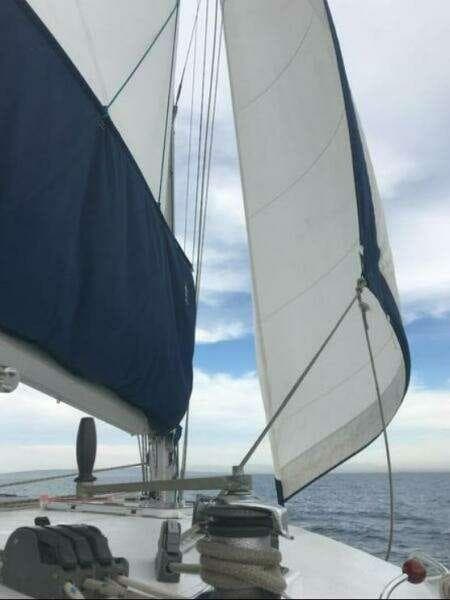 Sailing on a 2002 Wildcat MKIII 26 yacht with white sails against a cloudy sky.