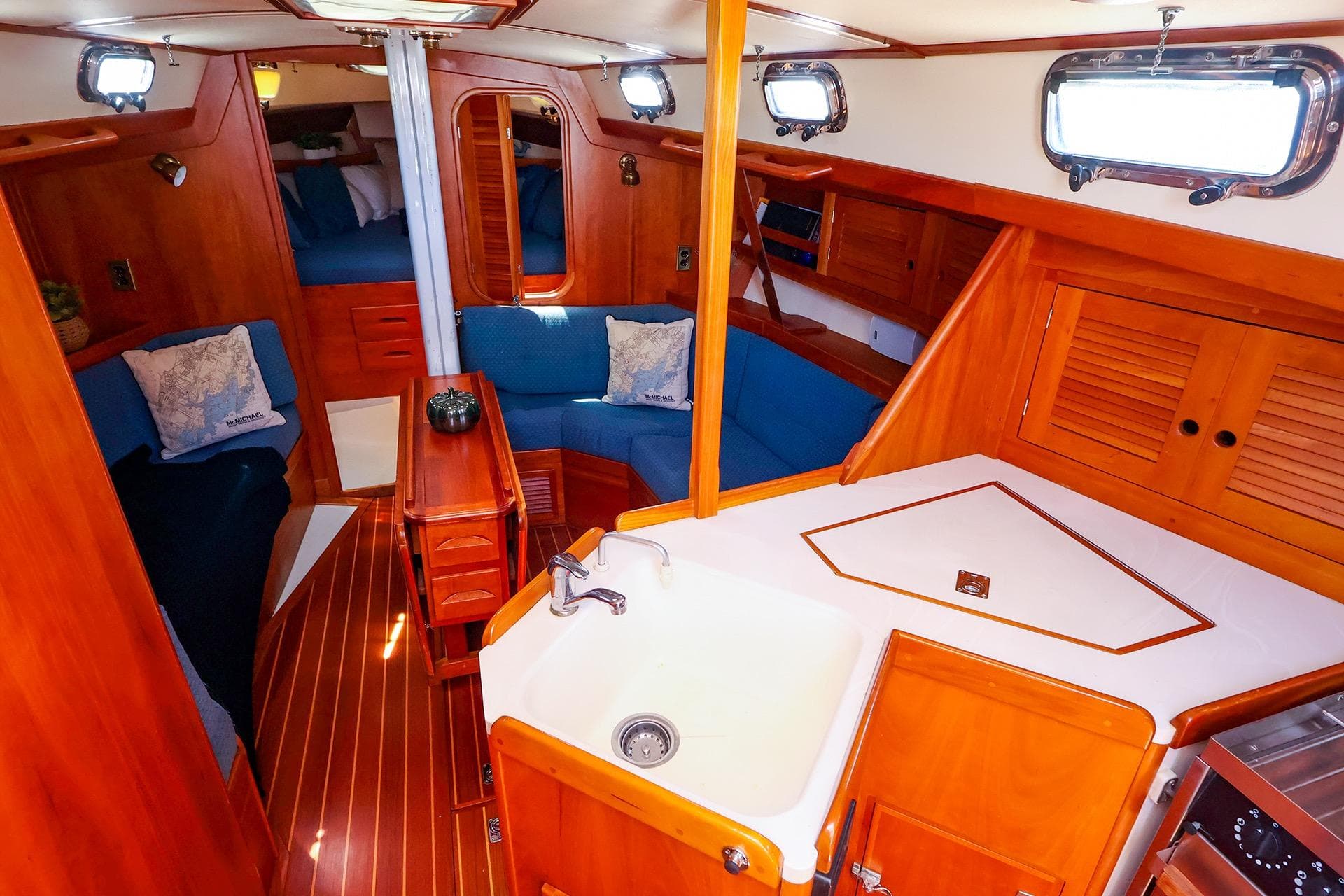 Interior of a 1999 Tartan 3500 sailboat with wood finish and cozy seating area.