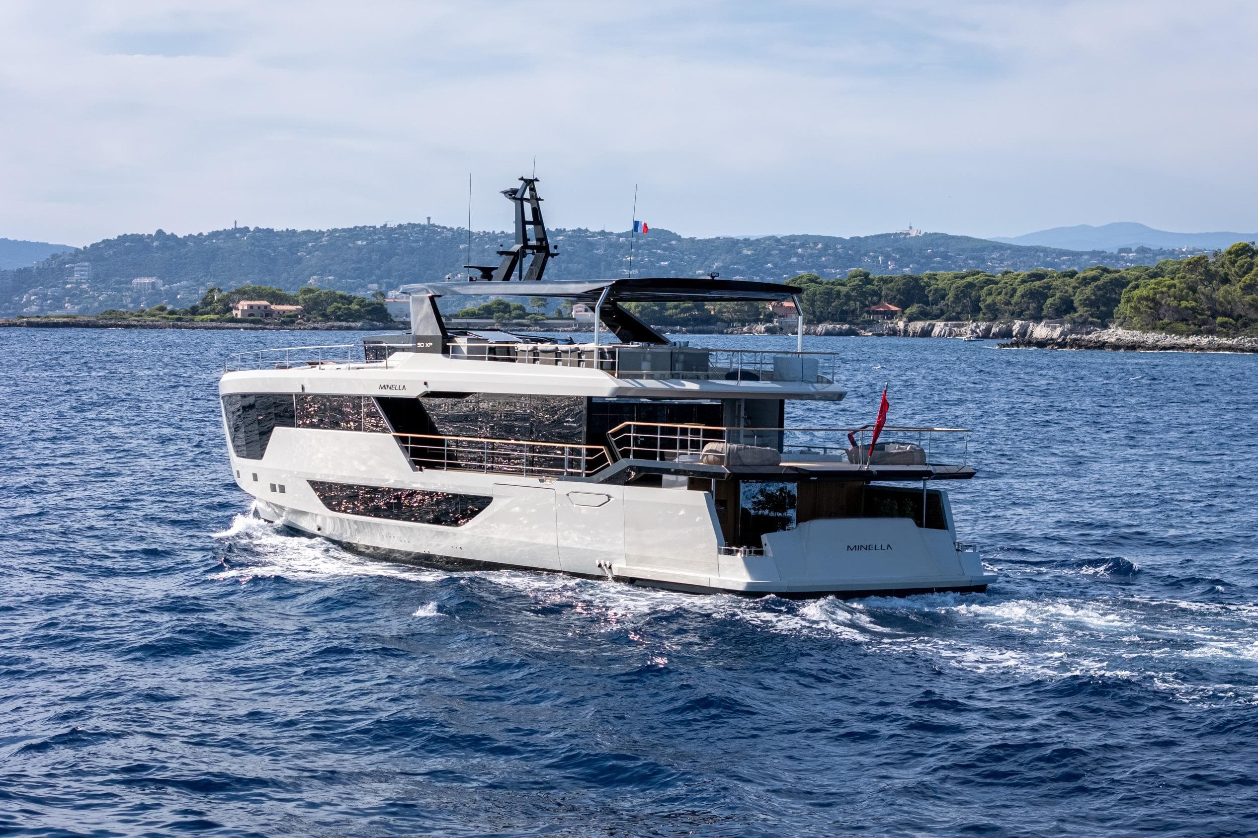 2025 Numarine 30XP yacht cruising on open sea near scenic coastline.