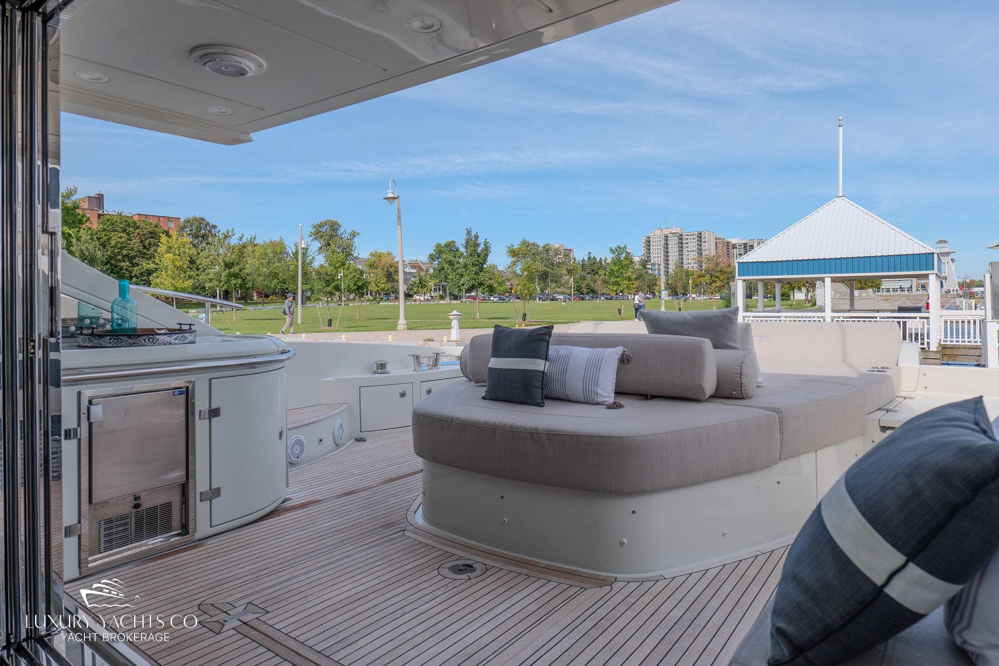 Luxurious 2010 Azimut 62S yacht deck with plush seating and scenic marina view.