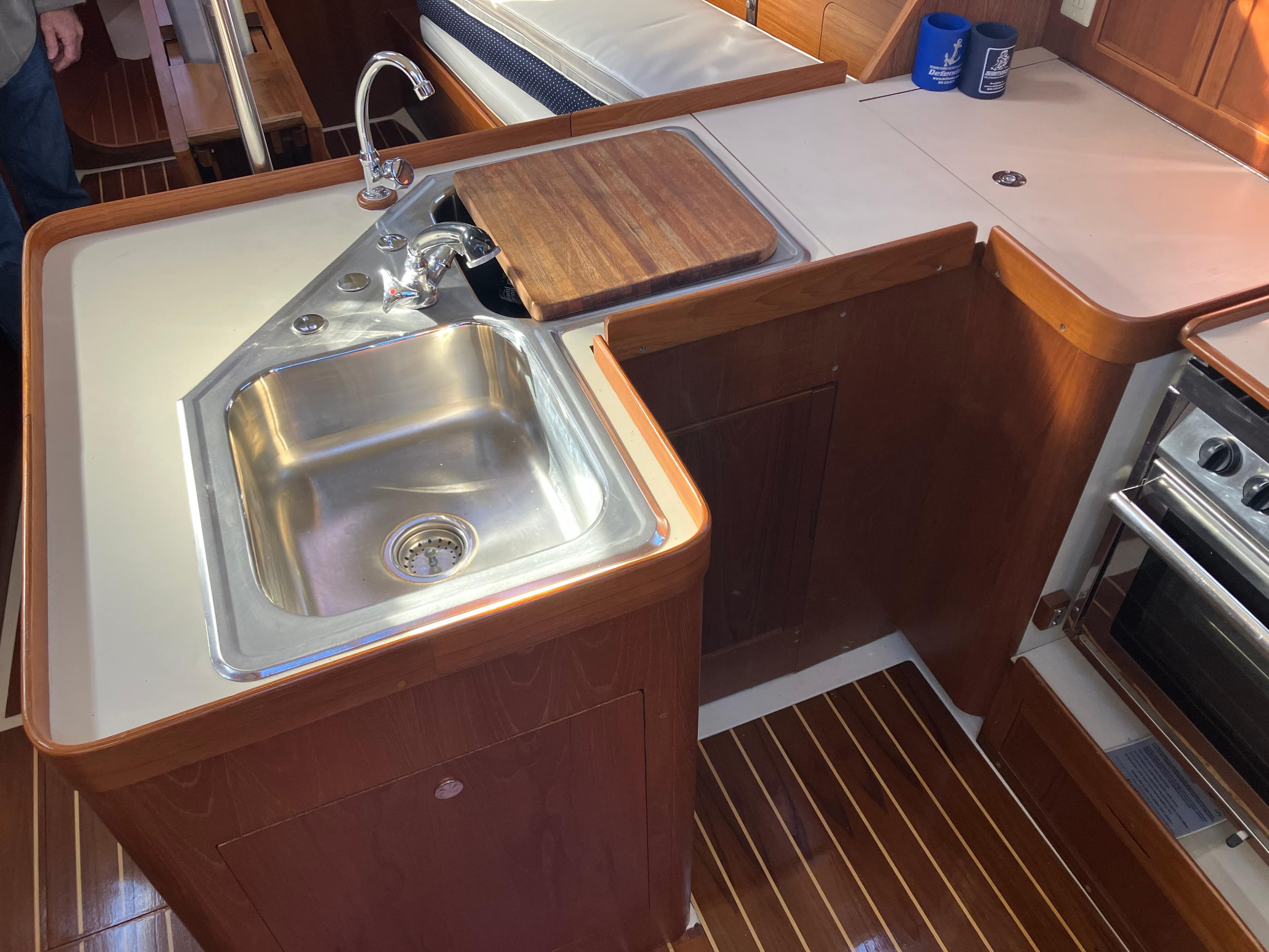 1989 Pearson 39-2 yacht kitchen with sink, faucet, and wooden countertop.