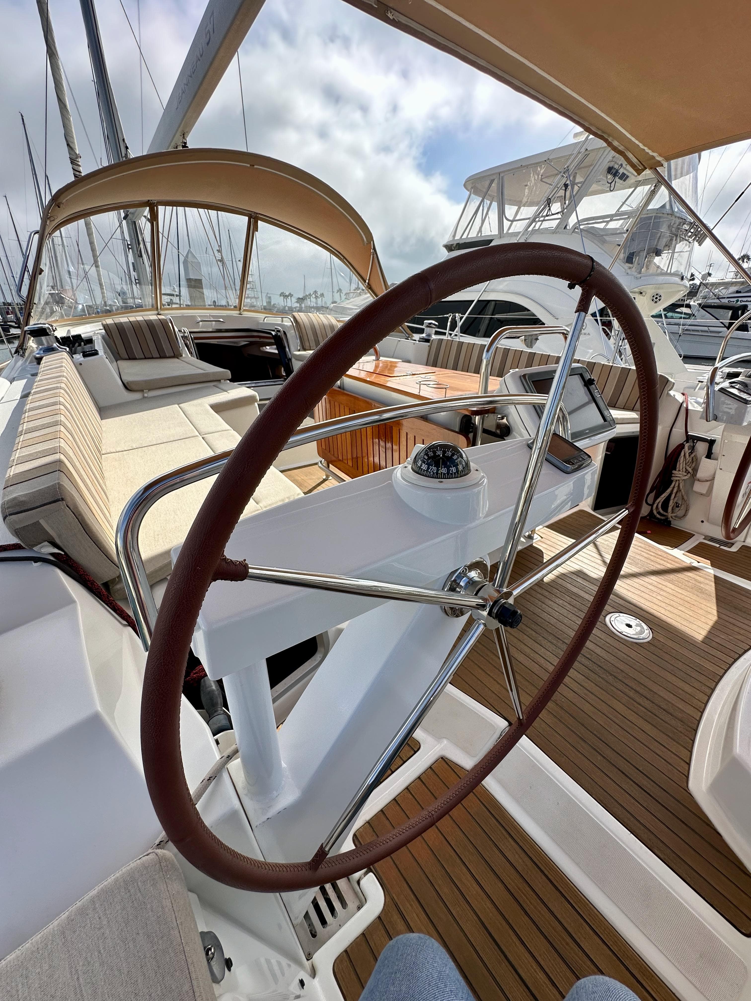 2014 Jeanneau 57 yacht cockpit with steering wheel and seating area.