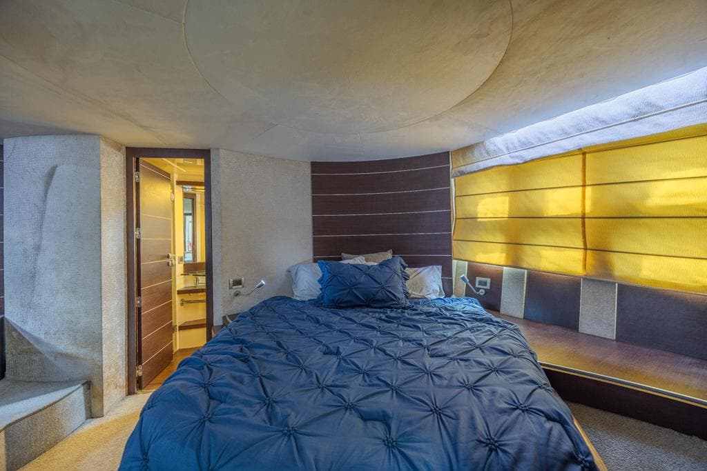 Luxurious bedroom interior of 2009 Azimut 68S yacht with modern design and cozy bedding.