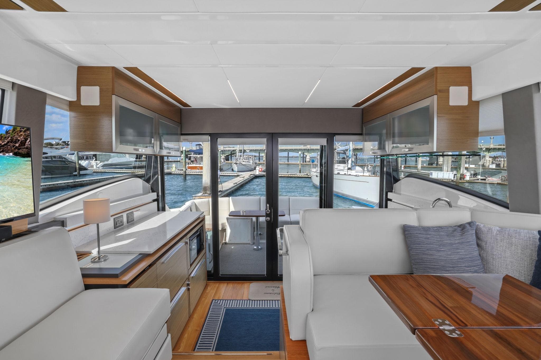 Luxurious interior of 2023 Tiara Yachts C49 Coupe with modern furnishings and marina view.
