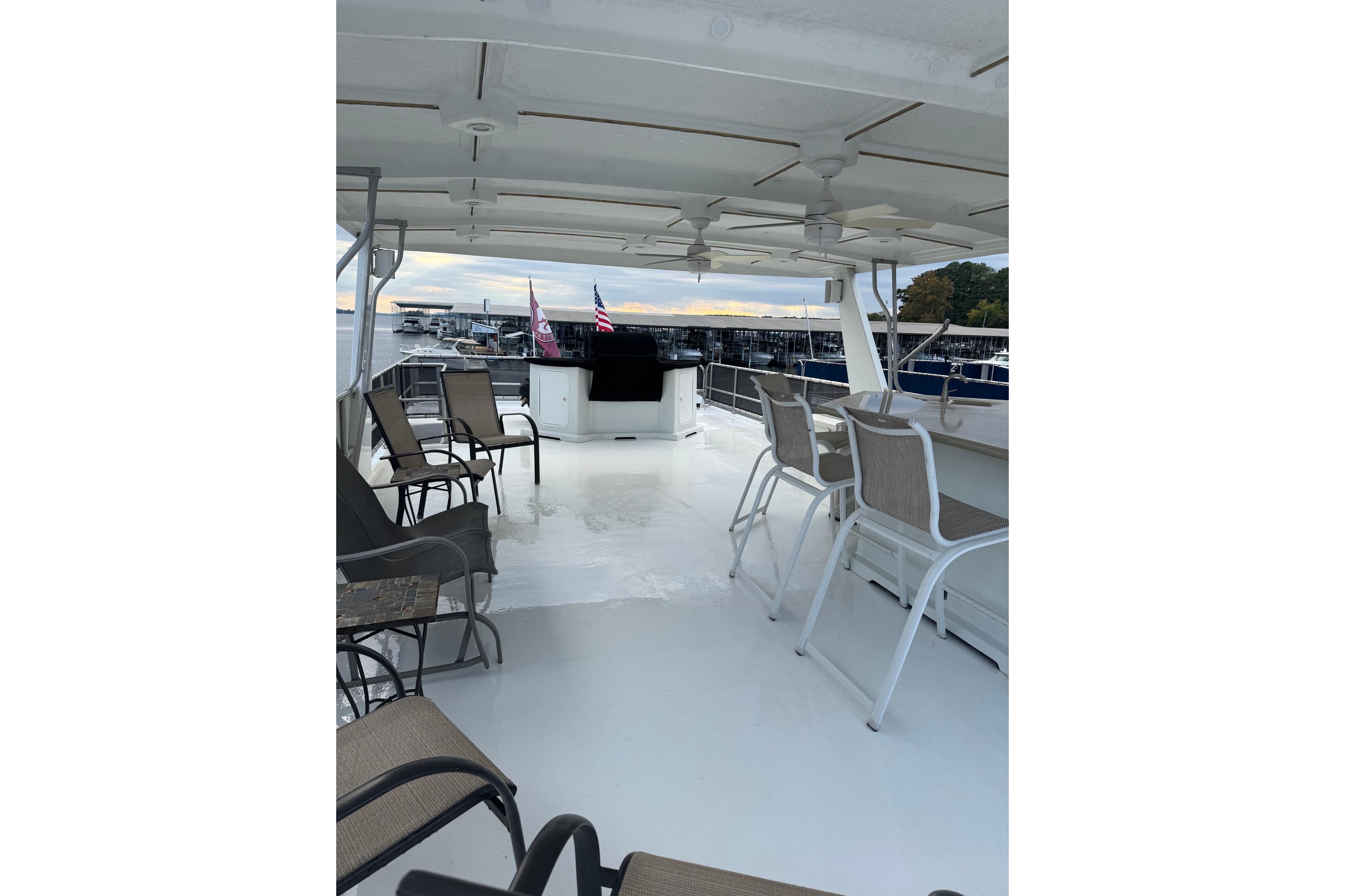Spacious deck of 2001 Sharpe 80 X 18 houseboat with seating and marina view.