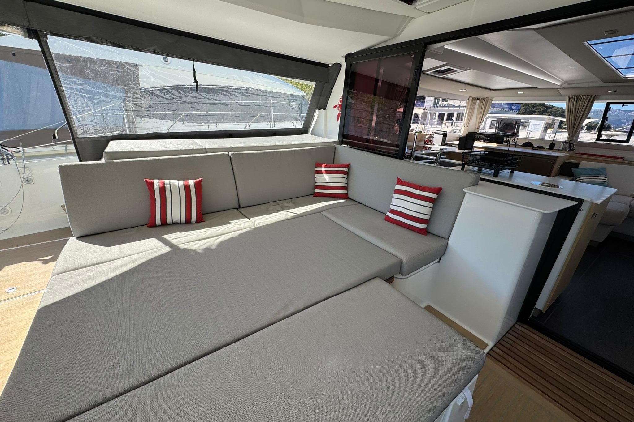 Luxurious interior of 2025 Fountaine Pajot Tanna 47 catamaran with modern seating and striped cushions.