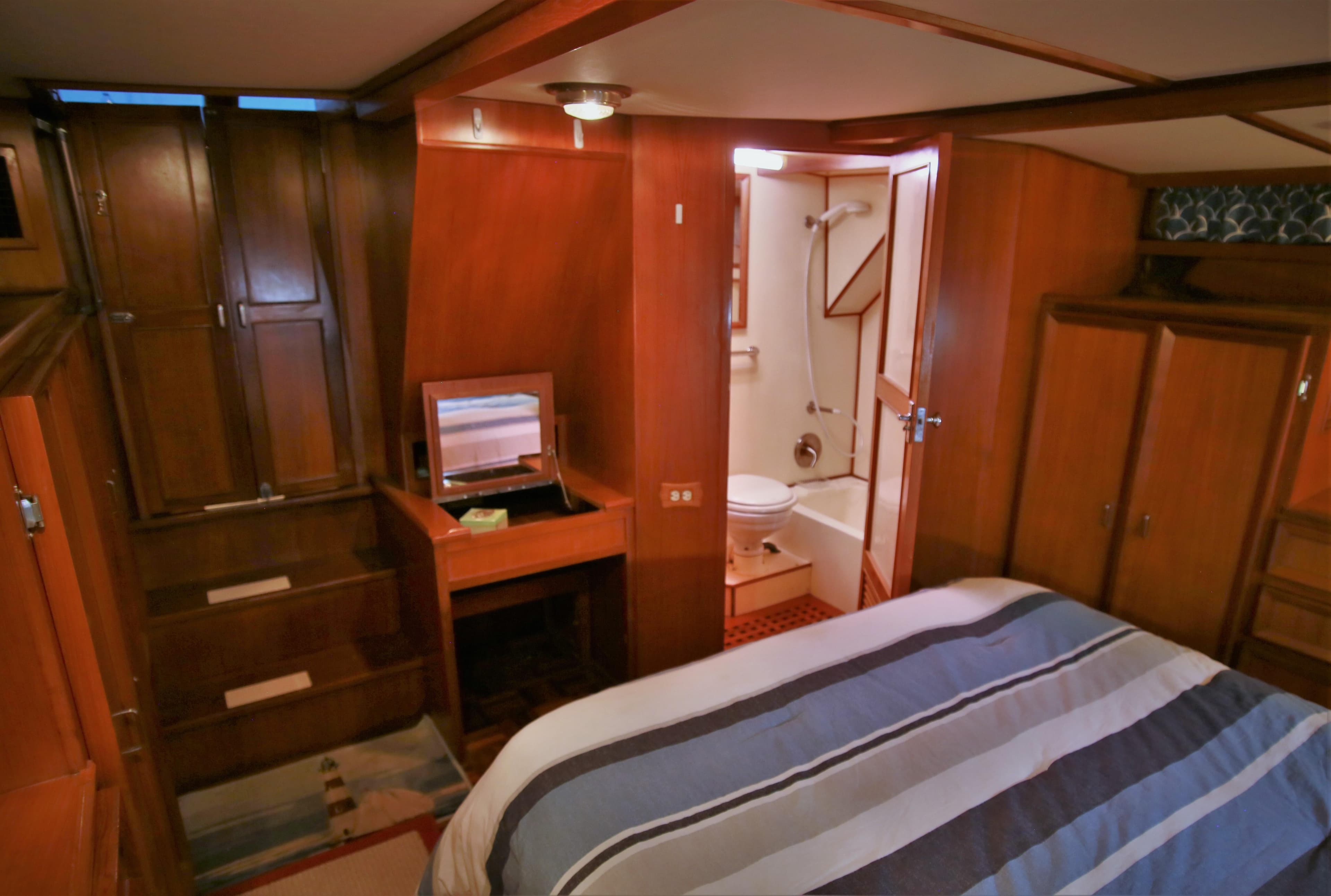 1987 Jefferson 42 Sundeck Motor Yacht interior cabin with bed and en-suite bathroom.