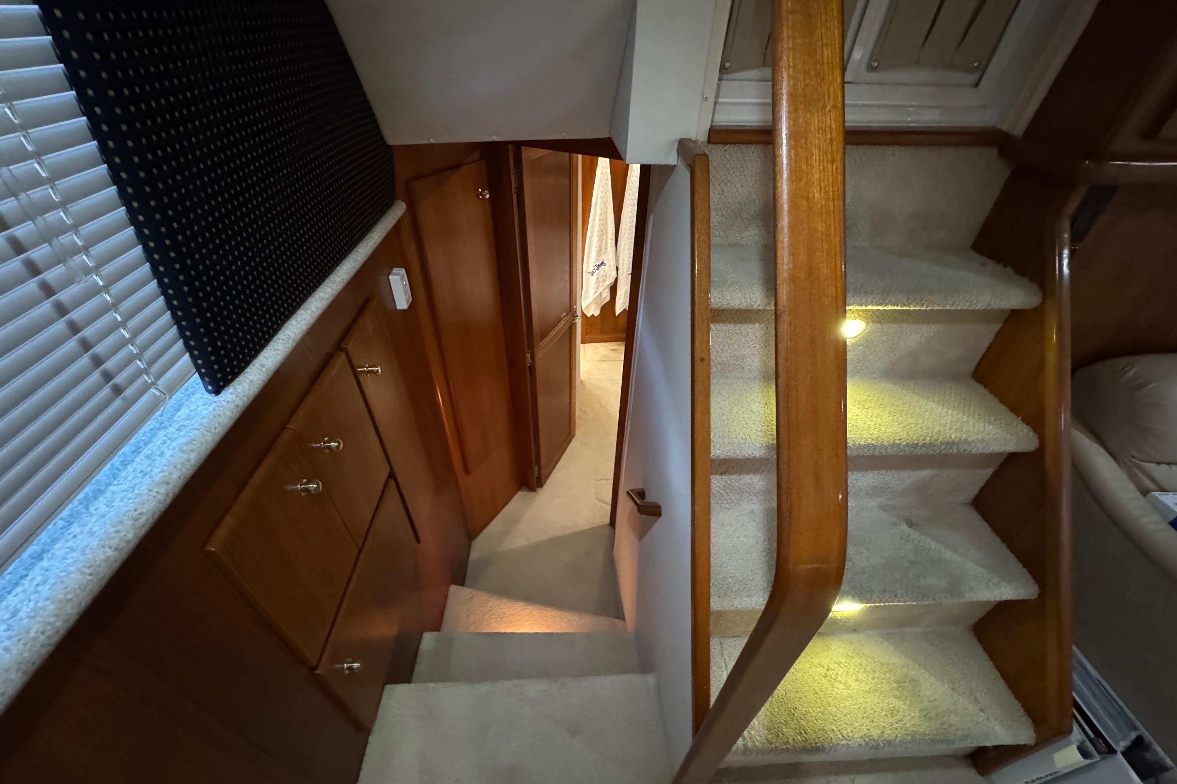 Interior of 2000 Carver 406 Aft Cabin Motor Yacht with carpeted stairs and wooden cabinetry.