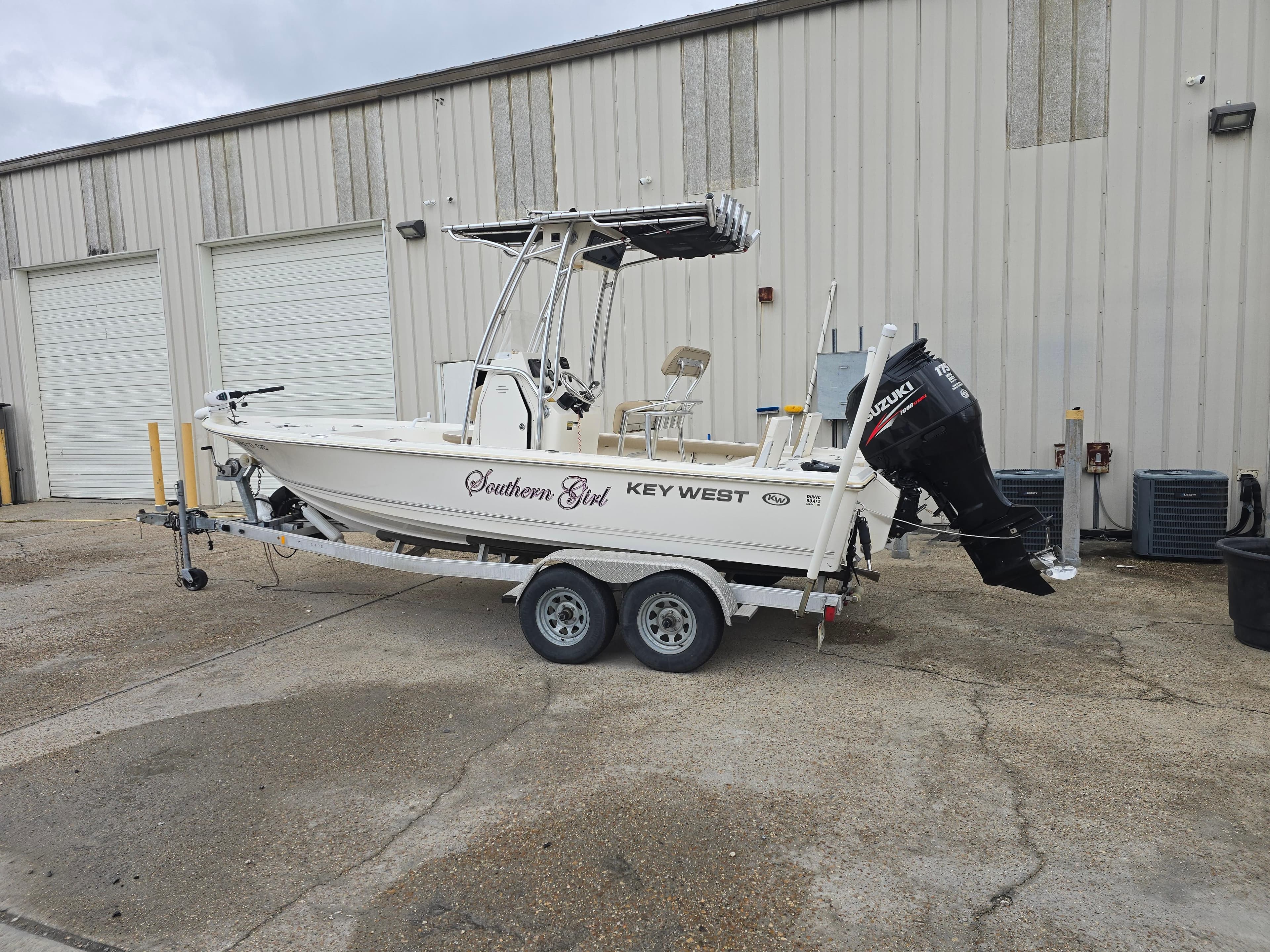 2014 Key West 210 Bay Reef boat on trailer, parked outside a warehouse.