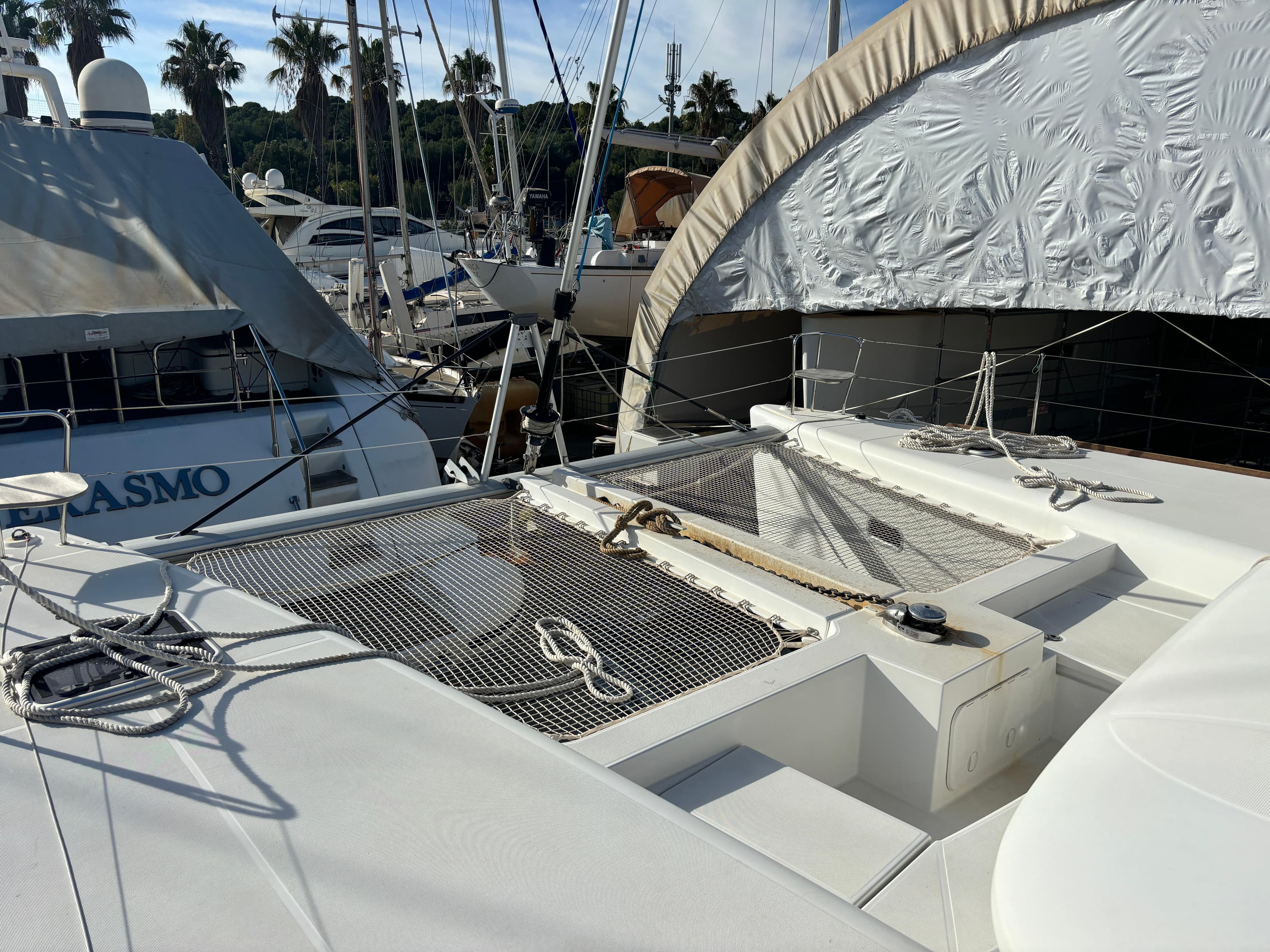 2019 Lagoon 450 F catamaran docked at marina with netting and ropes.
