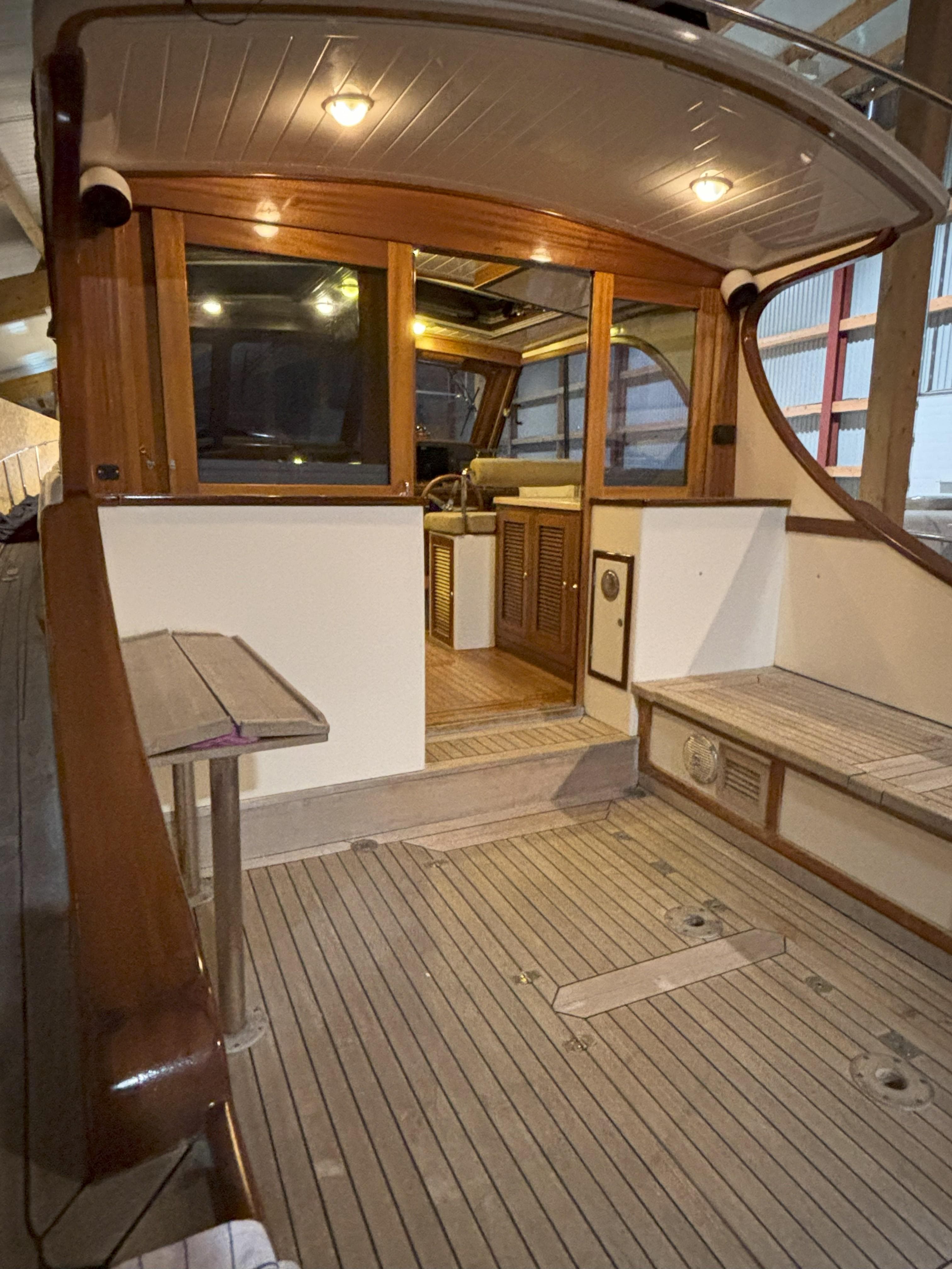 2003 Rapsody 48 yacht interior with wooden deck and seating area.