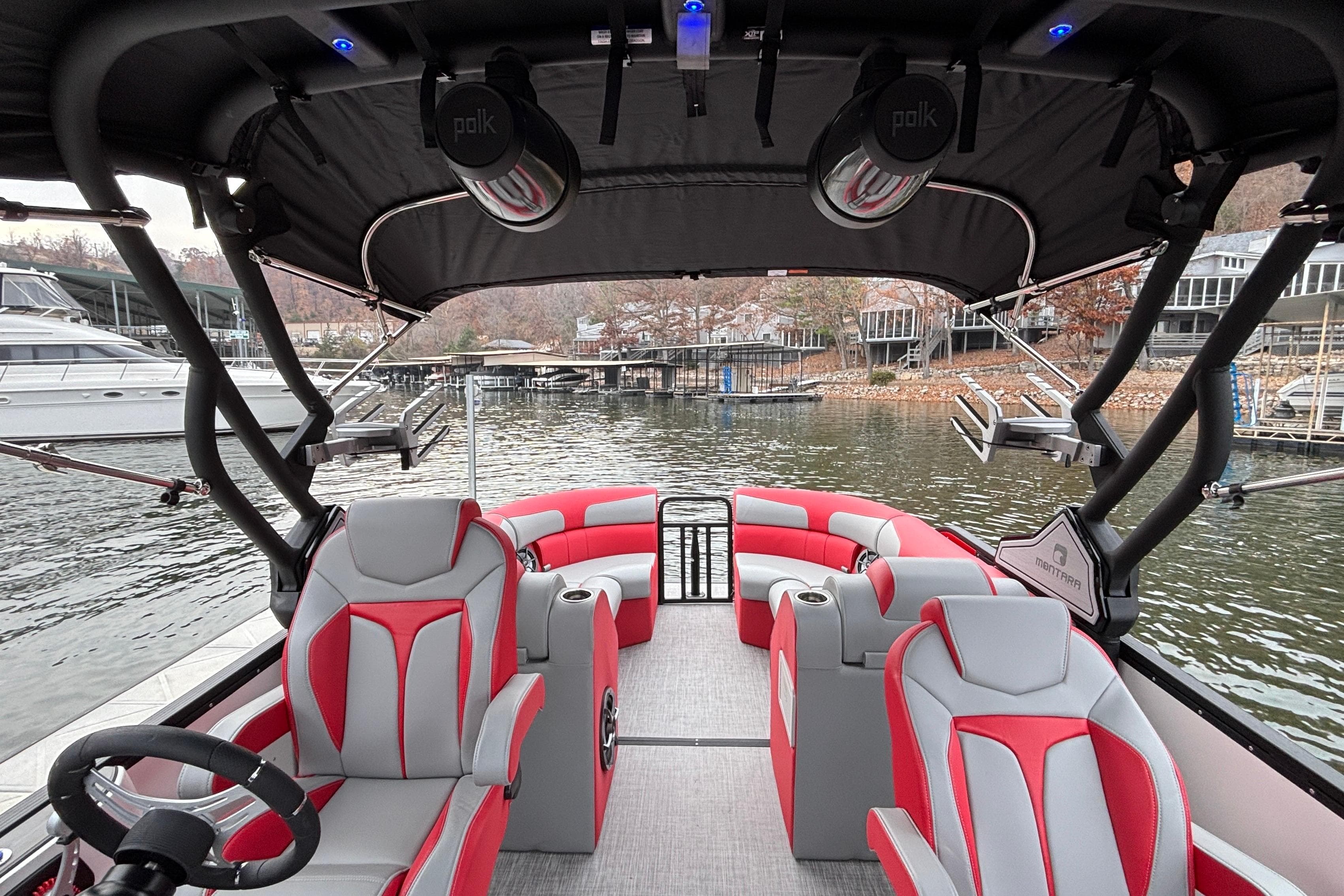 2025 Montara 25 Surf Boss boat interior with red and gray seating, docked by the water.