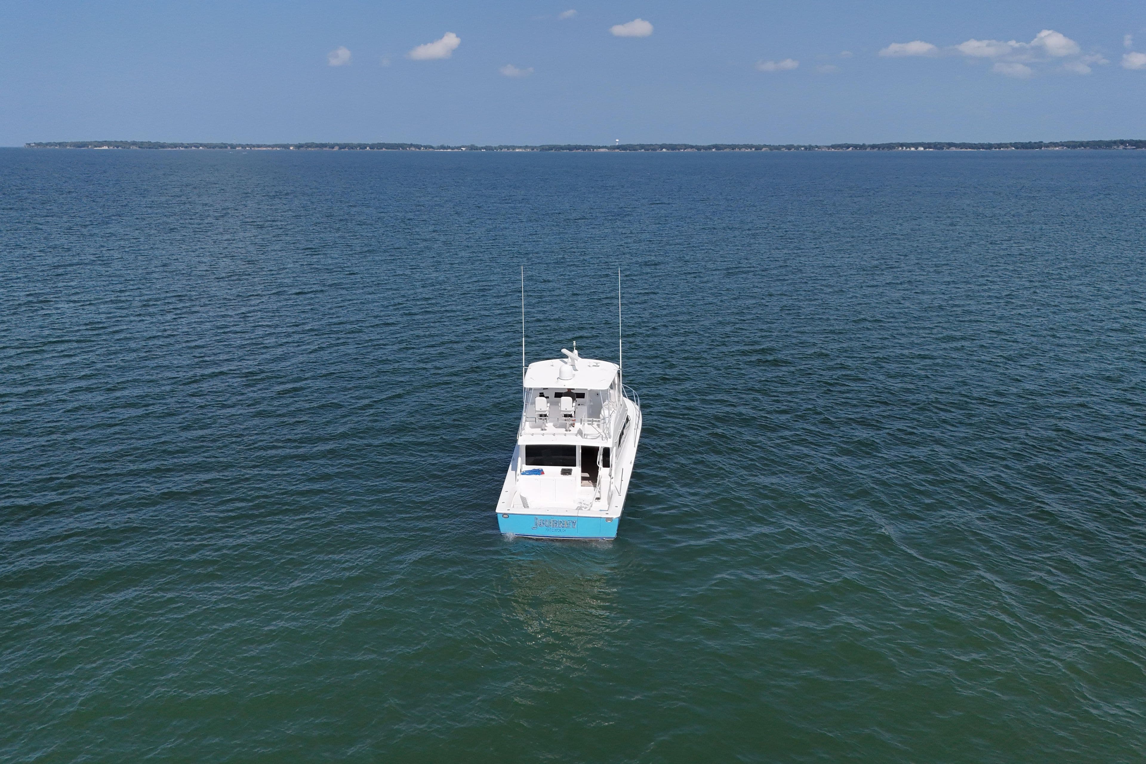 2003 Viking 48 Convertible yacht on open sea under clear sky.