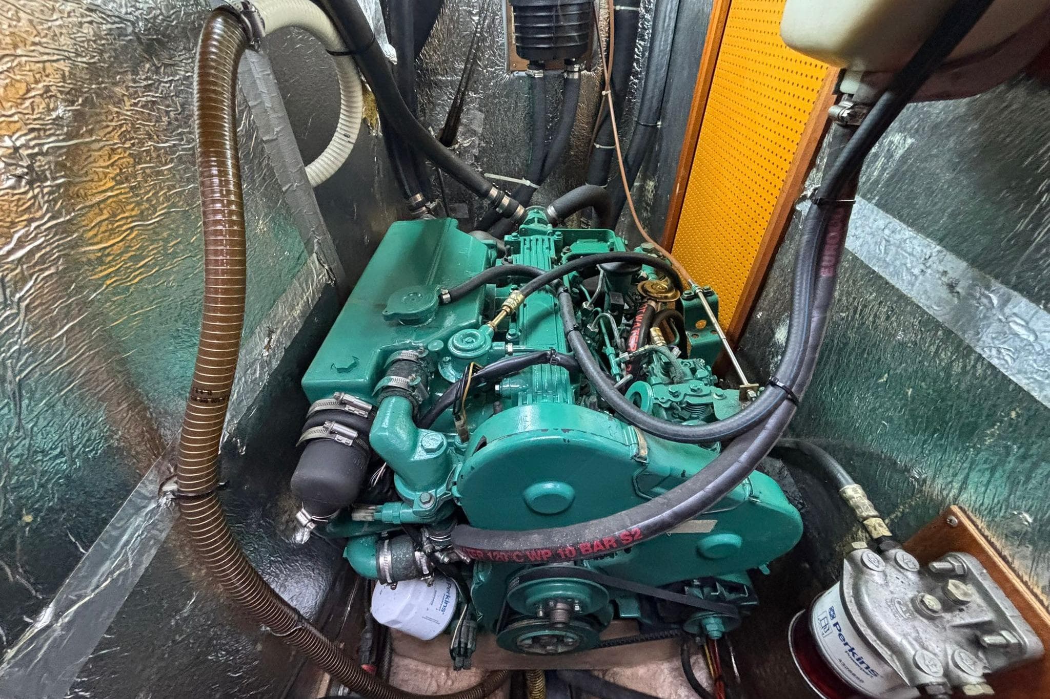 Engine compartment of a 1994 Najad 360 sailboat, featuring a green marine engine.