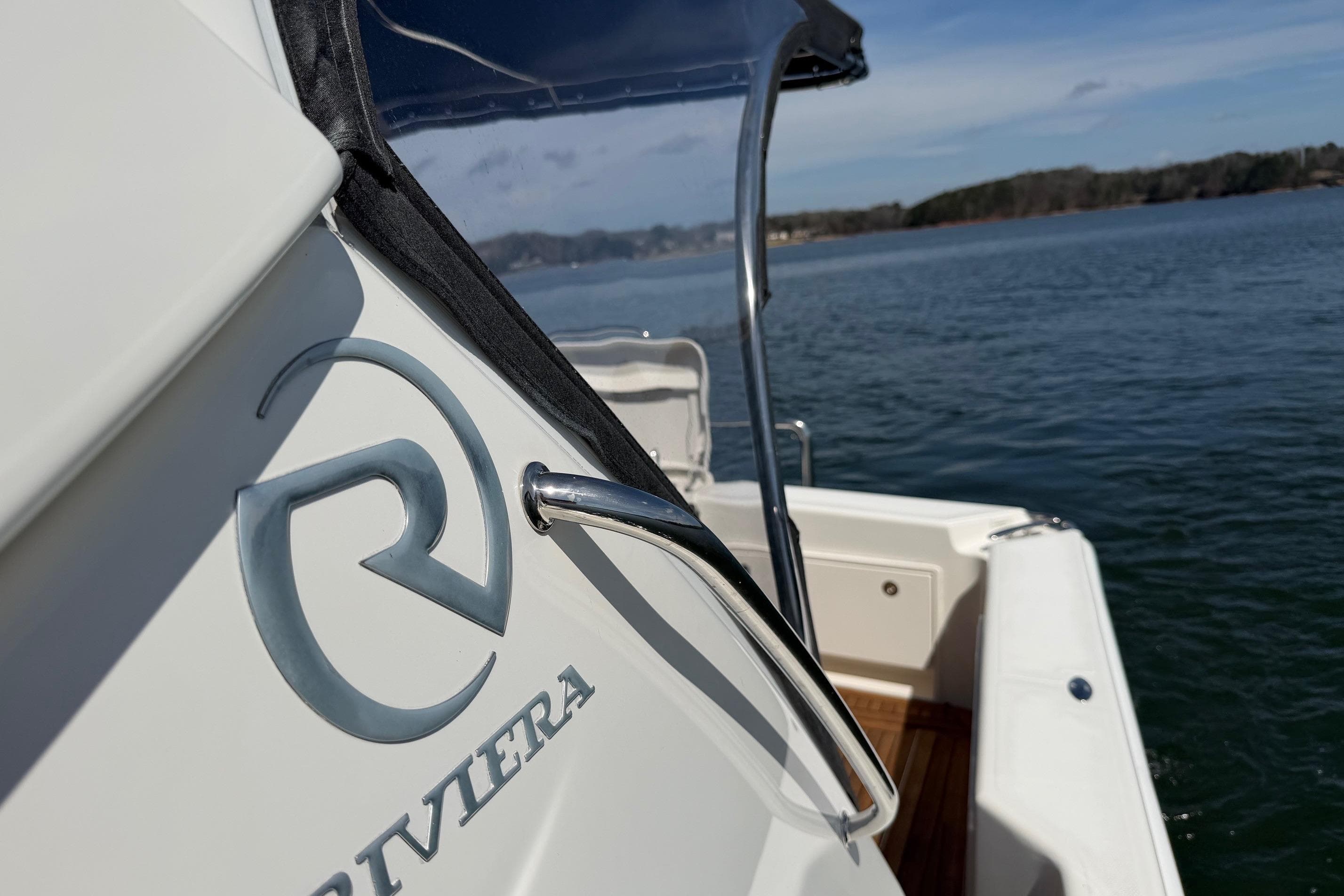 2016 Riviera 445 SUV boat on calm water, showcasing logo and sleek design.