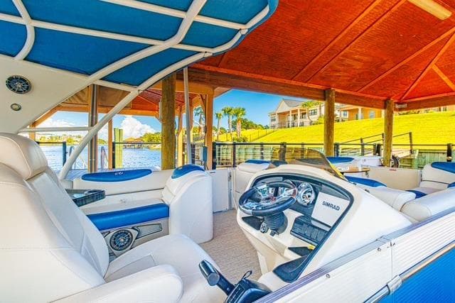 Luxurious 2020 Avalon Catalina 2585 boat interior with blue and white seating under a canopy.