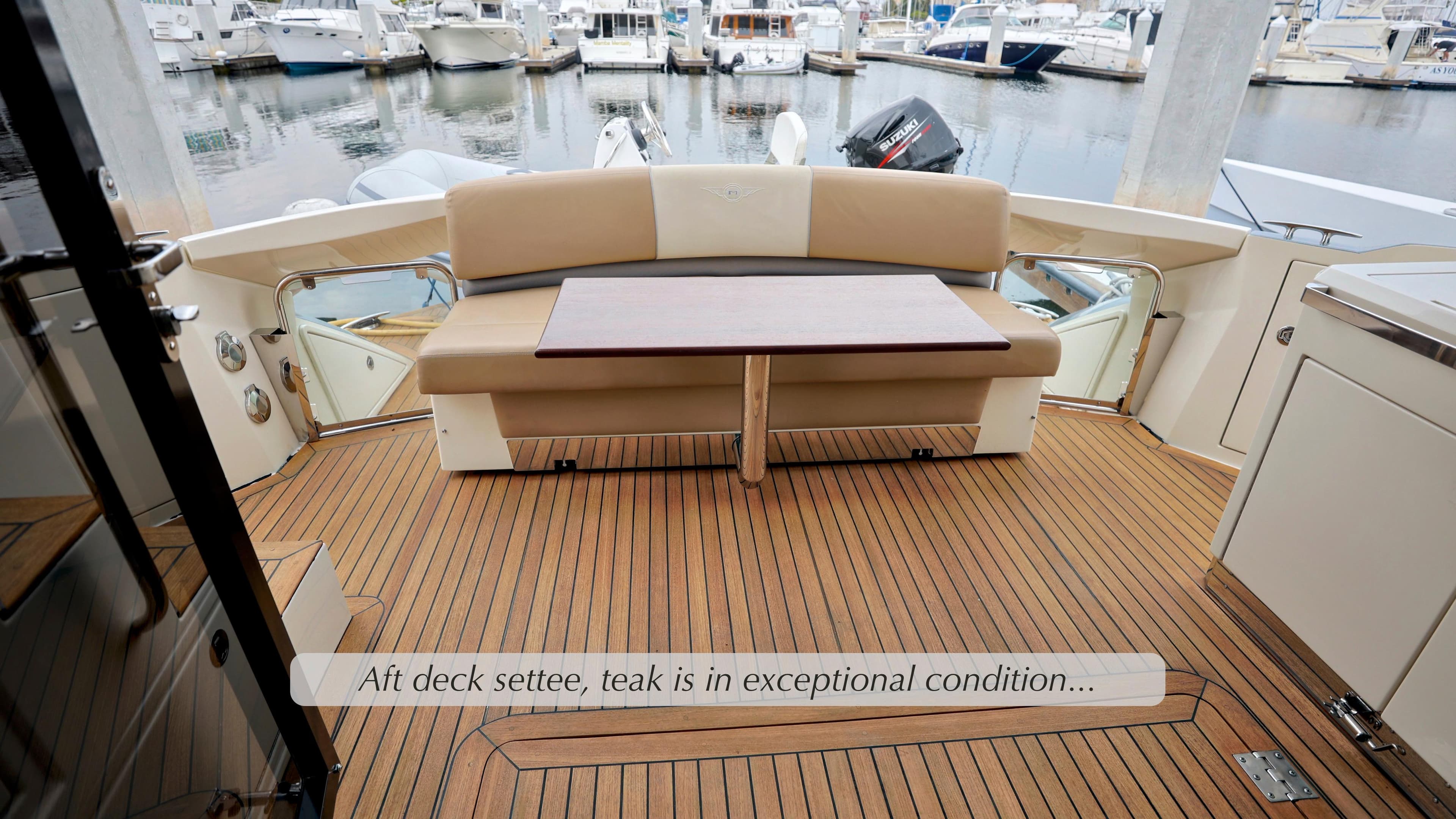 Aft deck settee on 2013 Marquis 500 Sport Bridge with teak flooring in excellent condition.