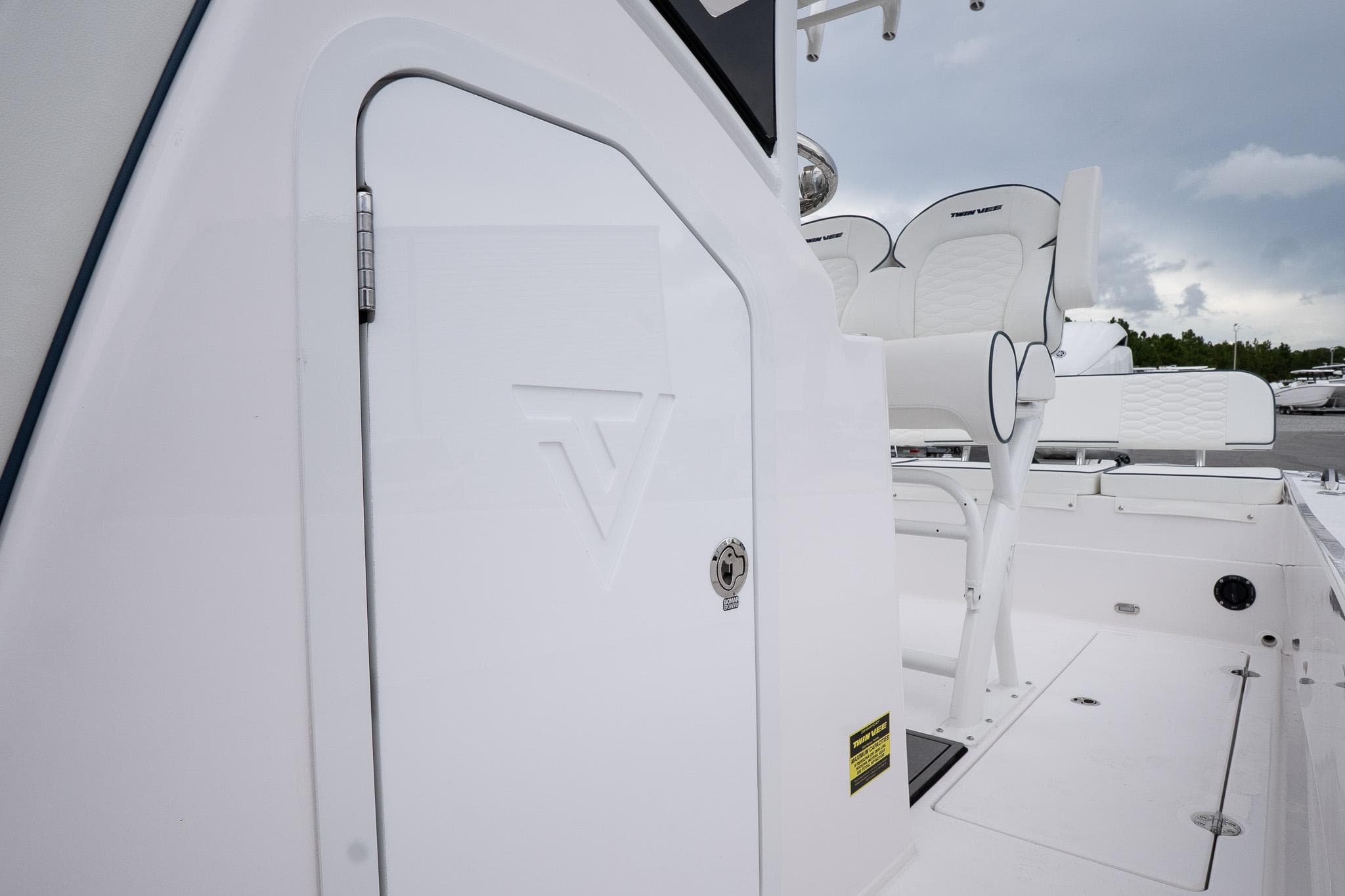 2026 Twin Vee 22 Bay Cat boat interior with white seating and storage compartment.