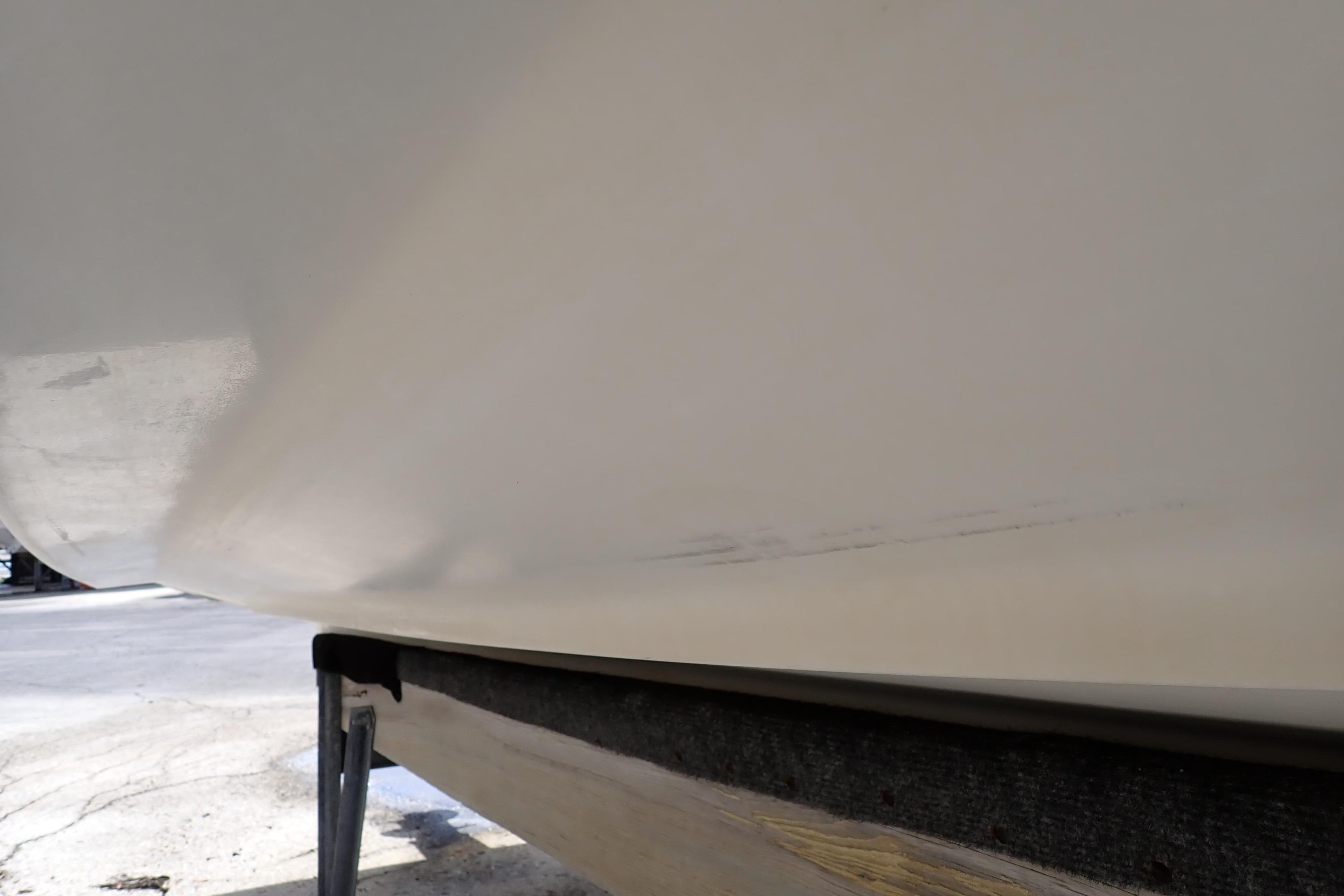 2005 Sea Ray Sundancer 260 hull on trailer, showing minor scuff marks.