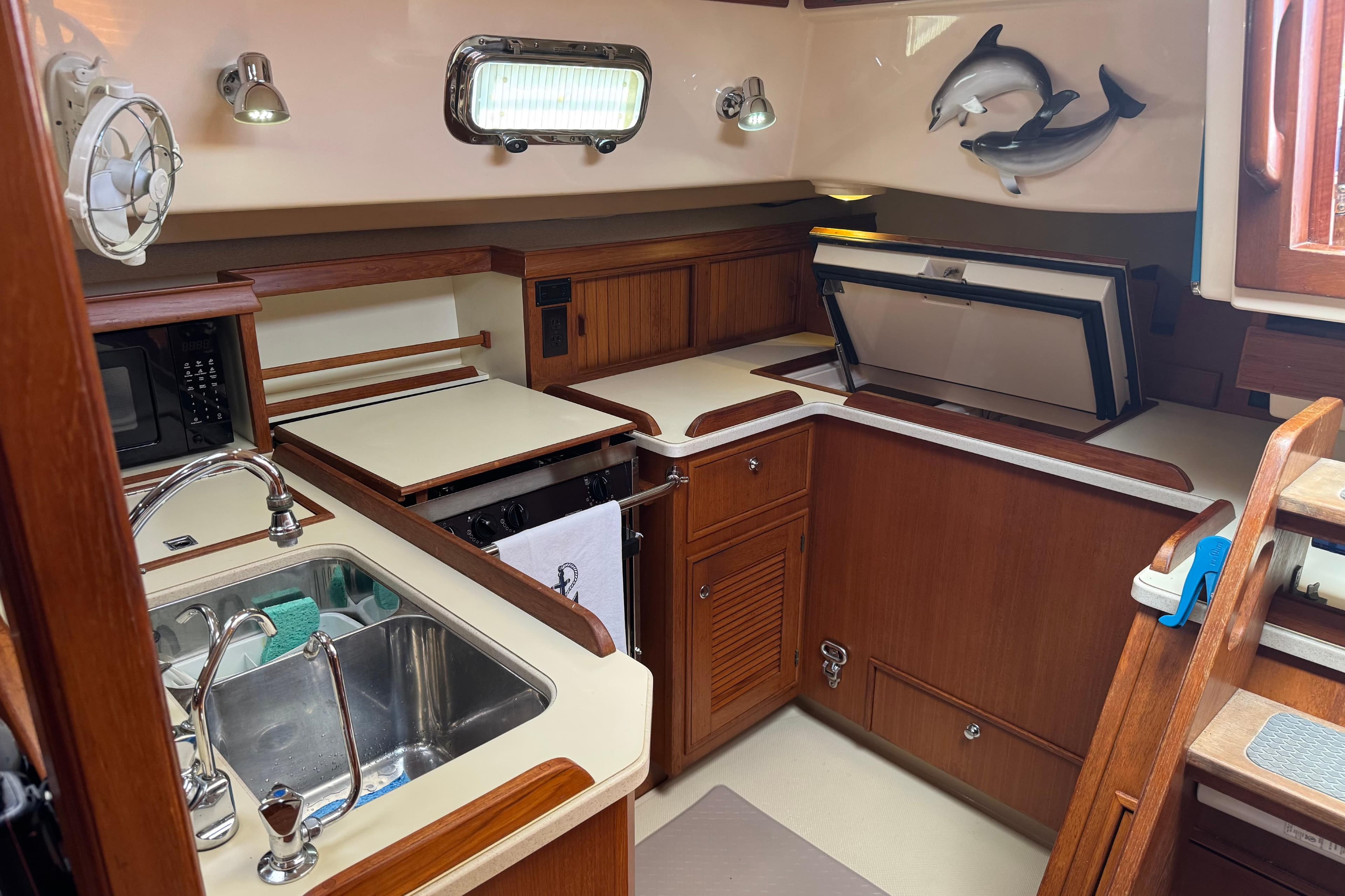 Interior of 2004 Island Packet 420 yacht kitchen with wooden cabinetry and stainless steel sink.